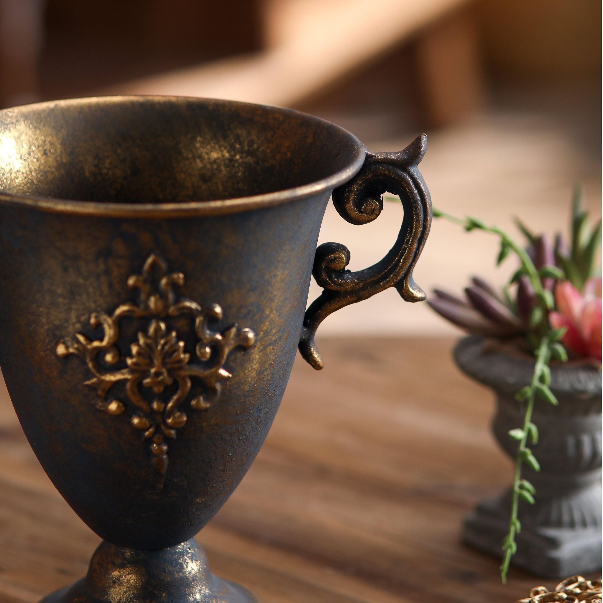 Isla footed goblet urn in bronze style finish styled beside a small grey urn