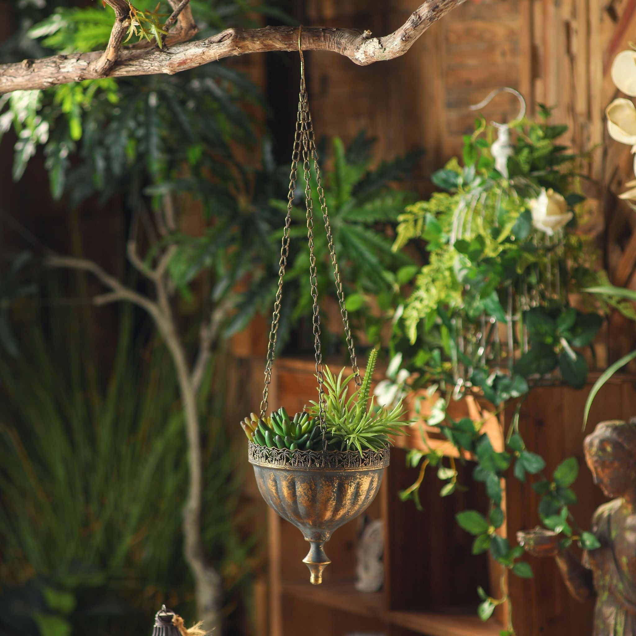 The three fine chains and hook of the Naxos hanging planter over a branch