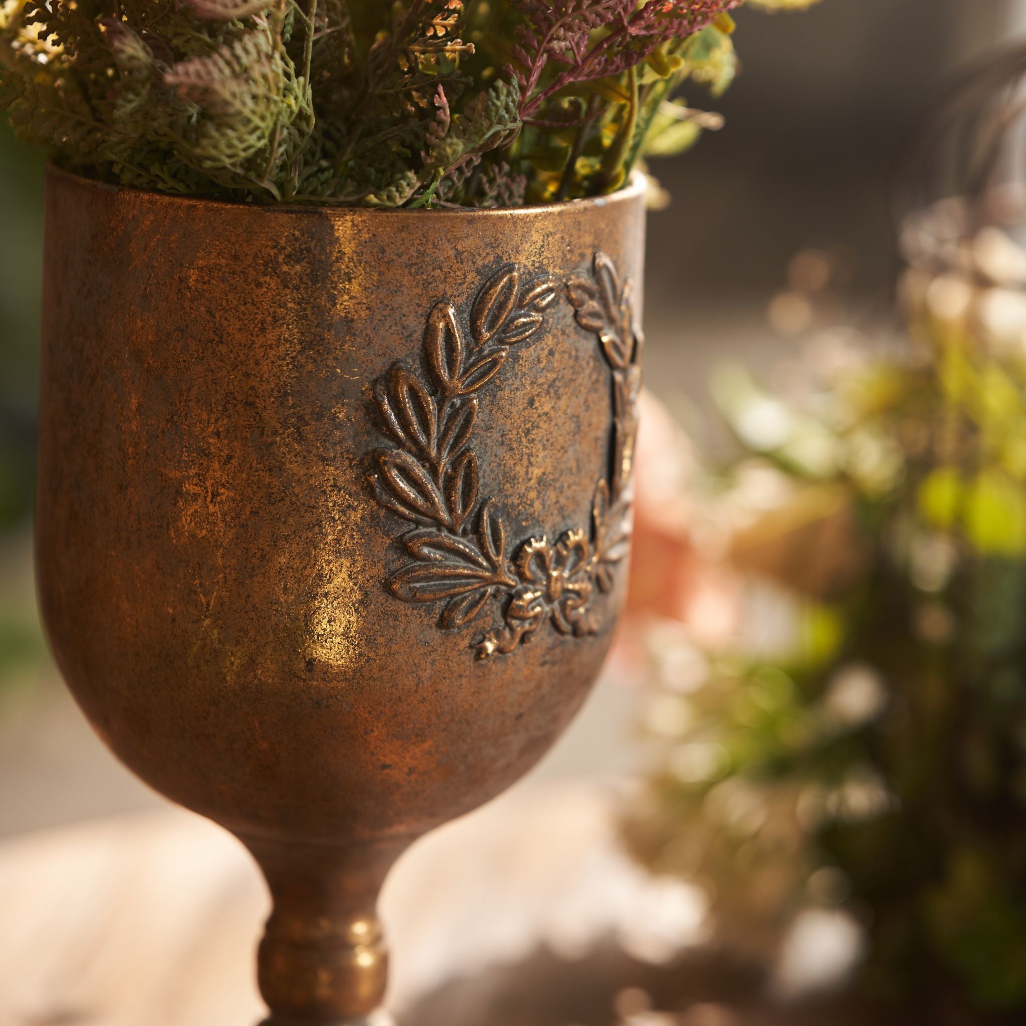 Close view of the raised laurel wreath and bow on the Norma goblet urn