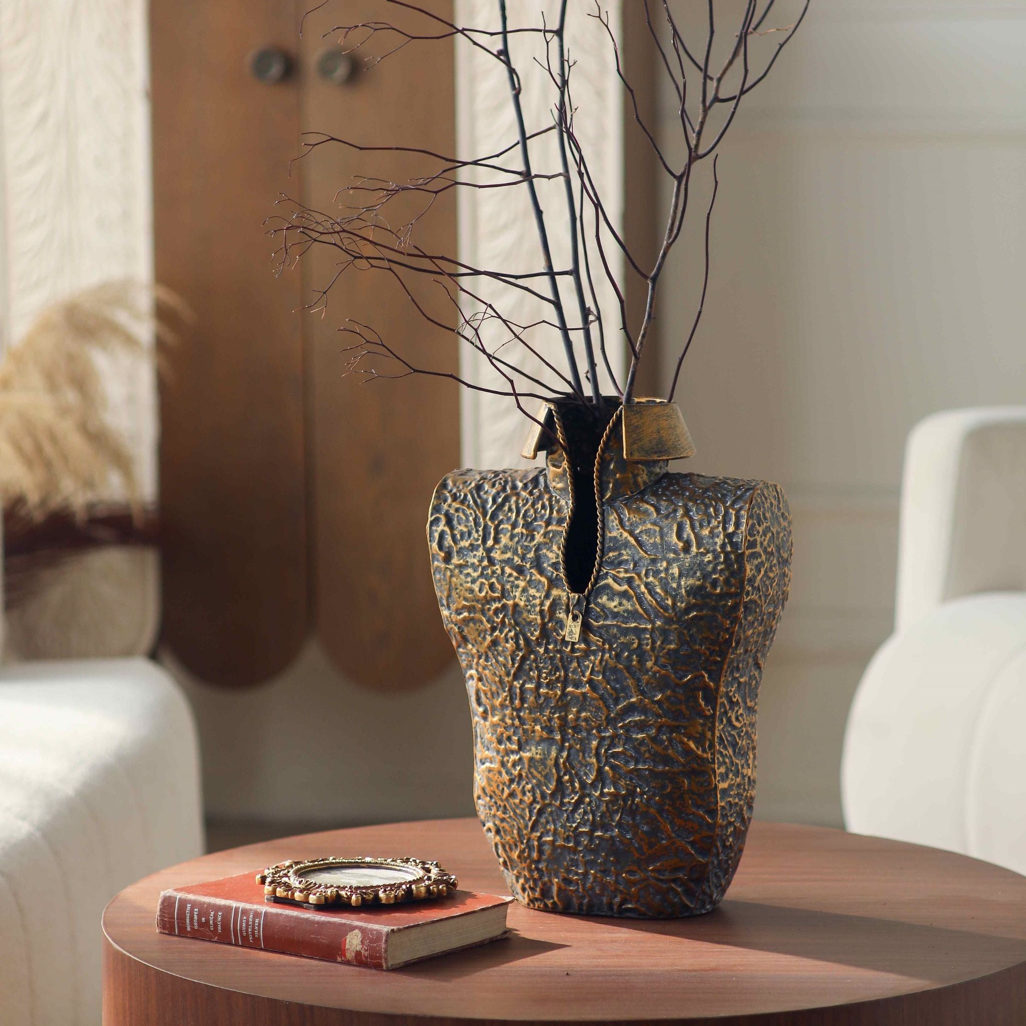 Aldo torso vase in textured bronze finish with collar and zip on a round table