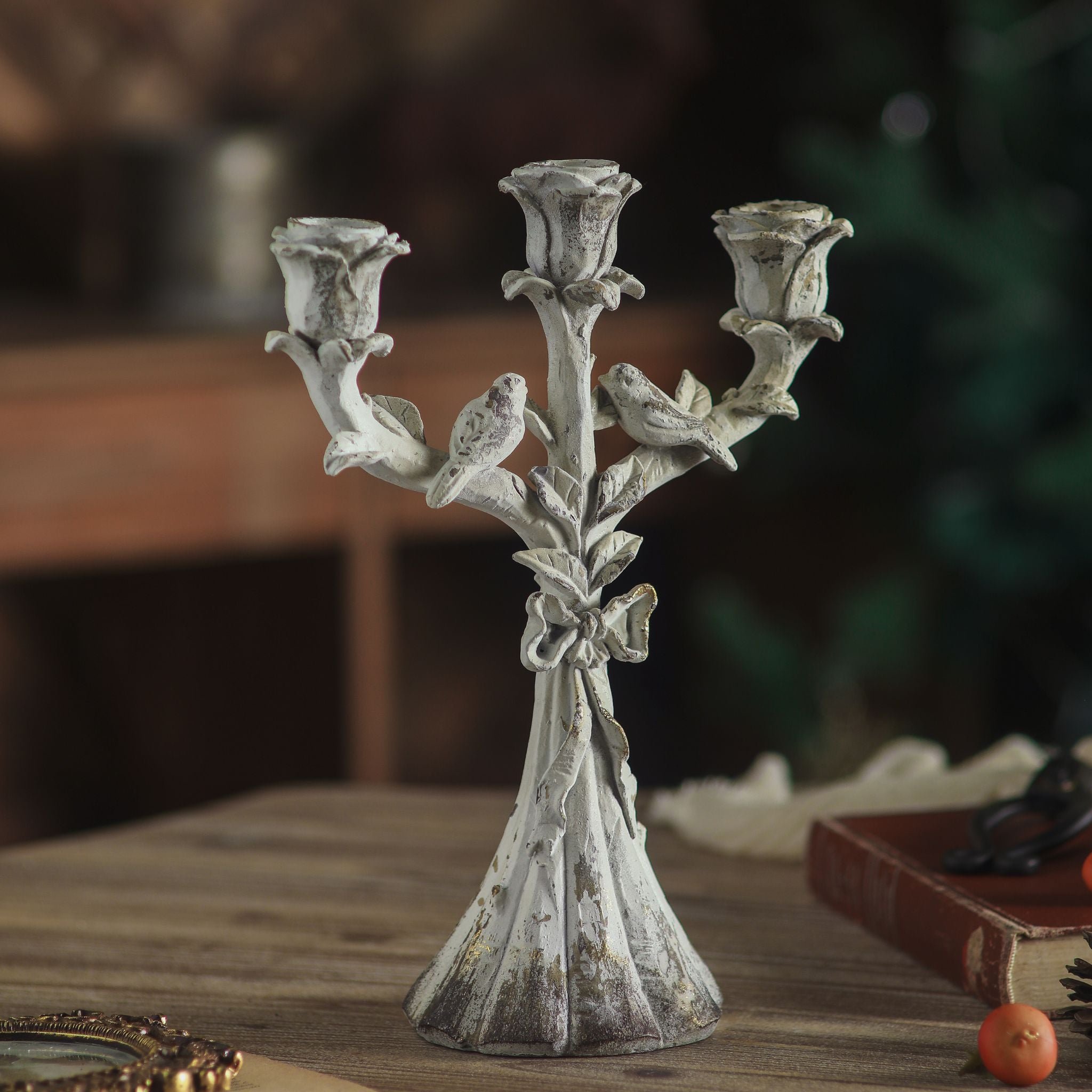 Close view of the three rose candle cups on the Corfu candelabra with lit candles