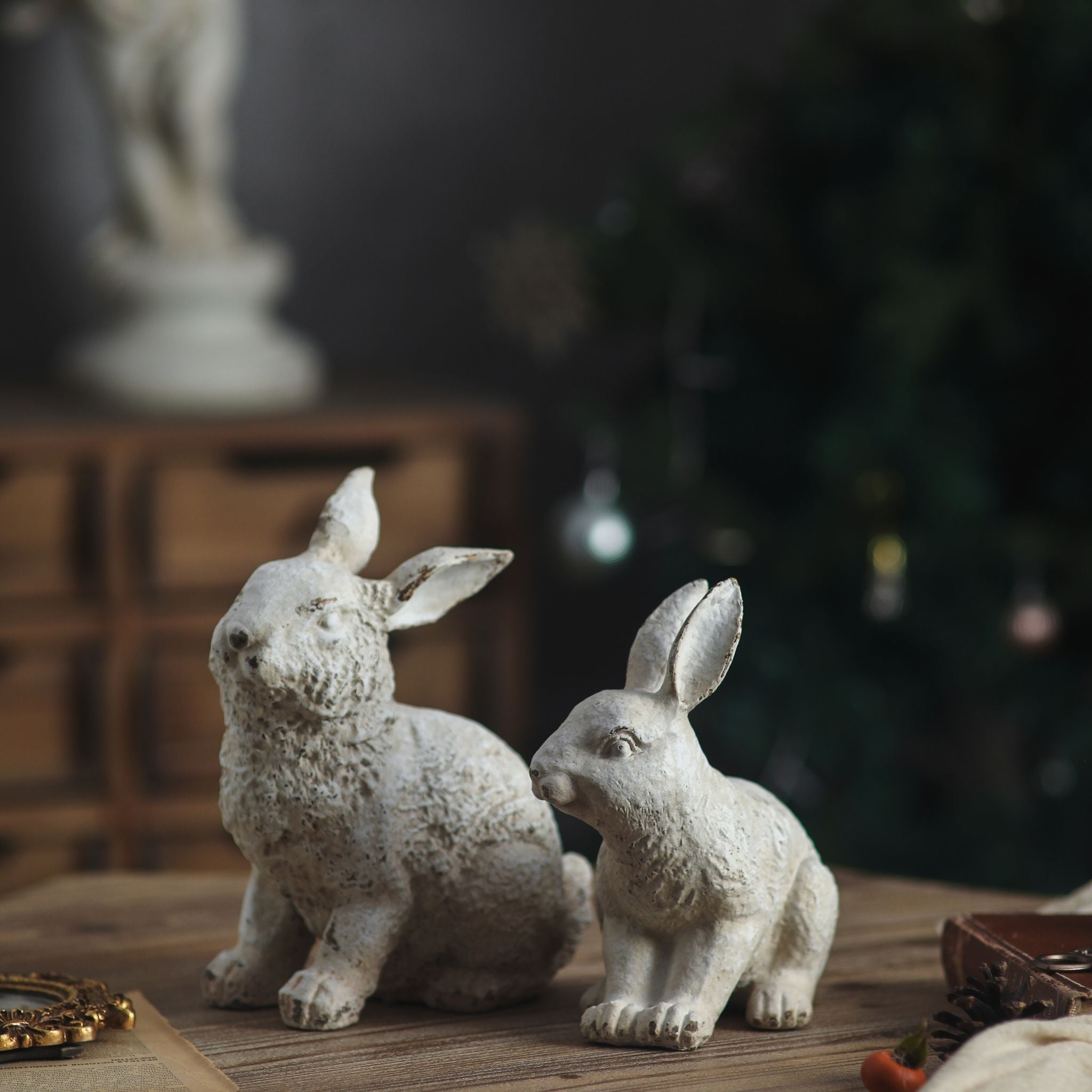 Dante rabbit sculpture beside Delia, the larger crouching rabbit, on a table