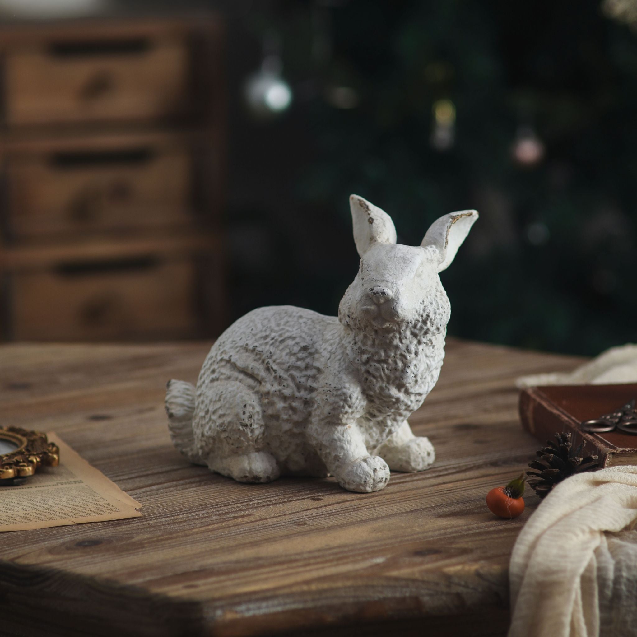 Delia crouching rabbit sculpture in aged white with textured coat on a timber table