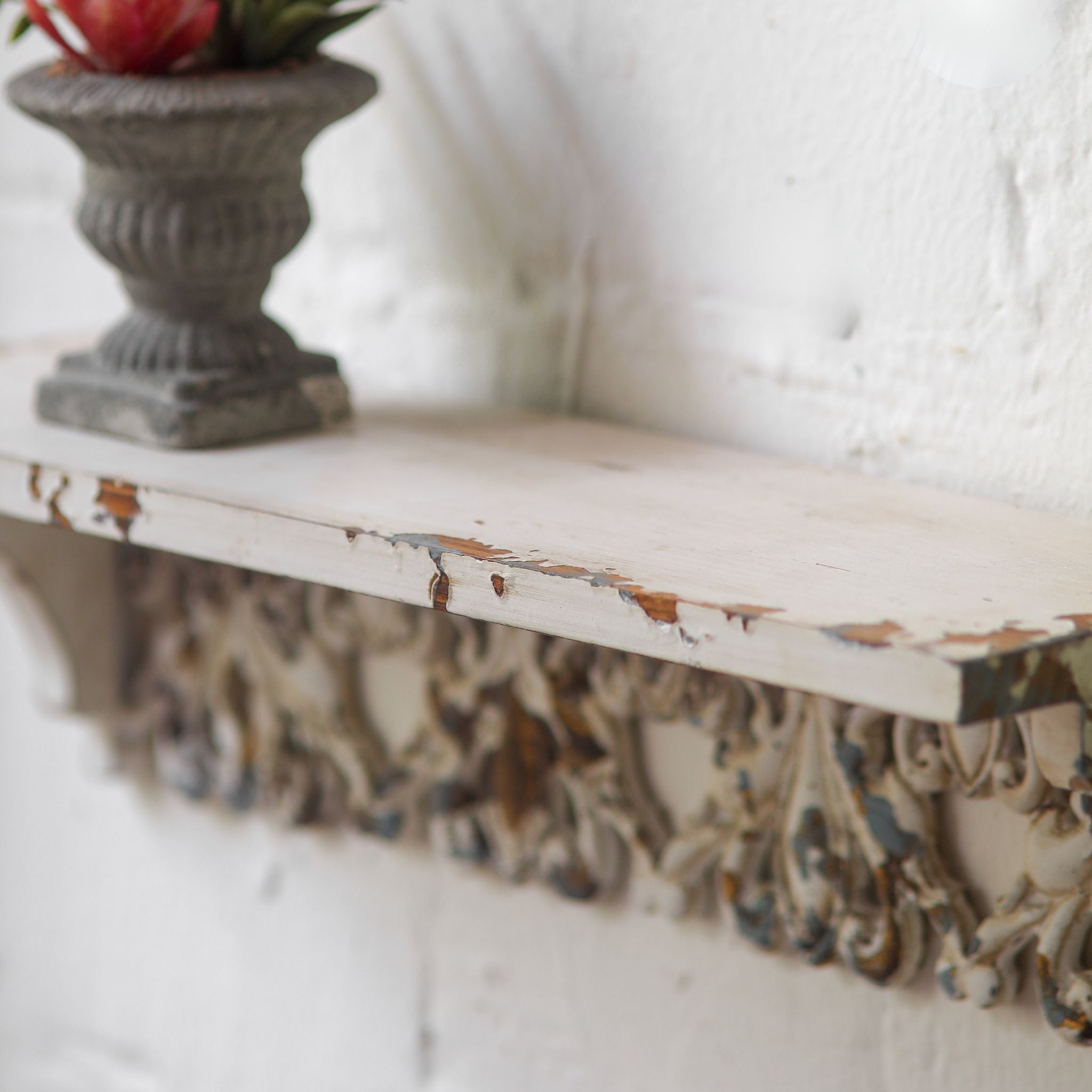 Elias fretwork wall shelf styled with a glass bottle and small urn planter