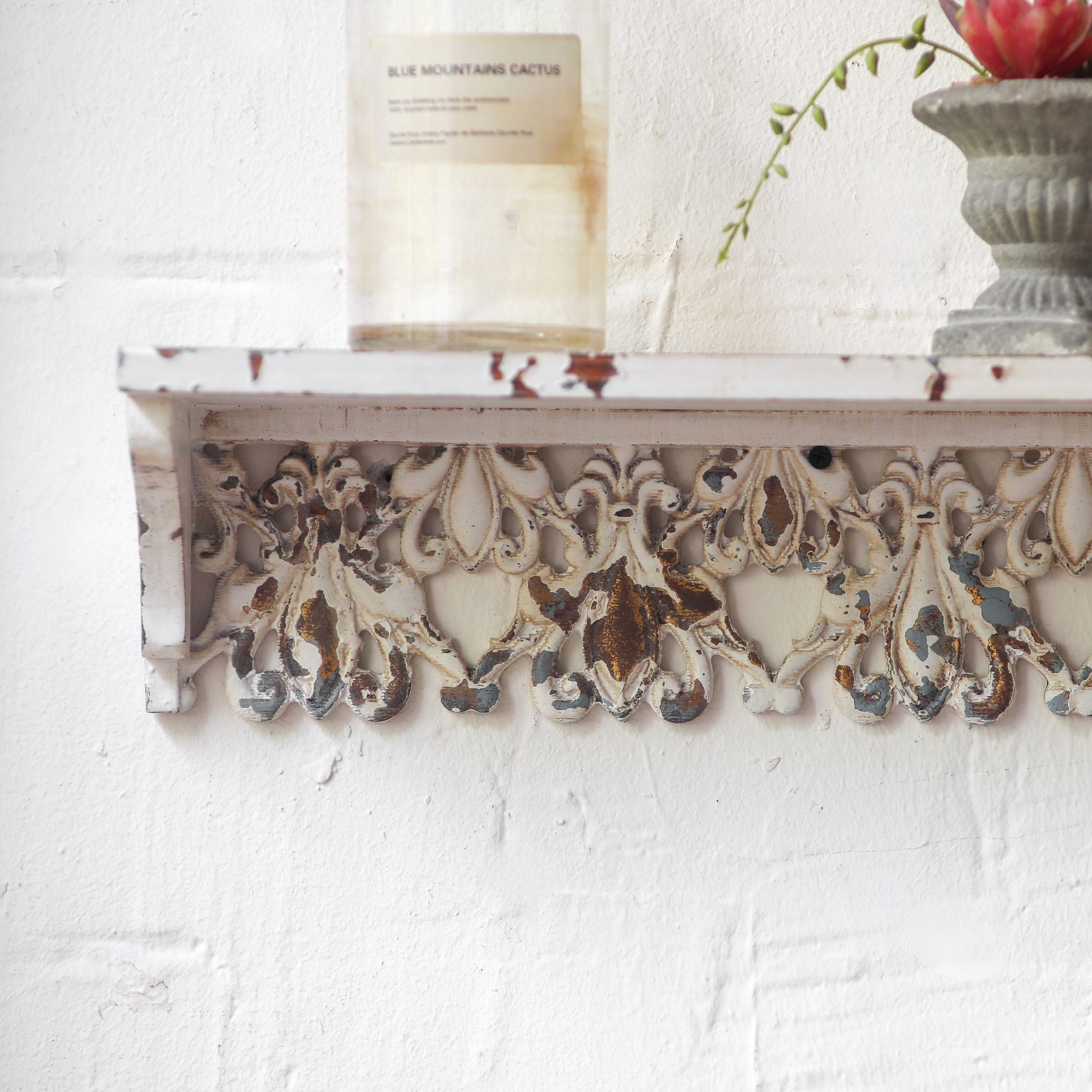 Elias carved fretwork wall shelf front view on a white brick wall