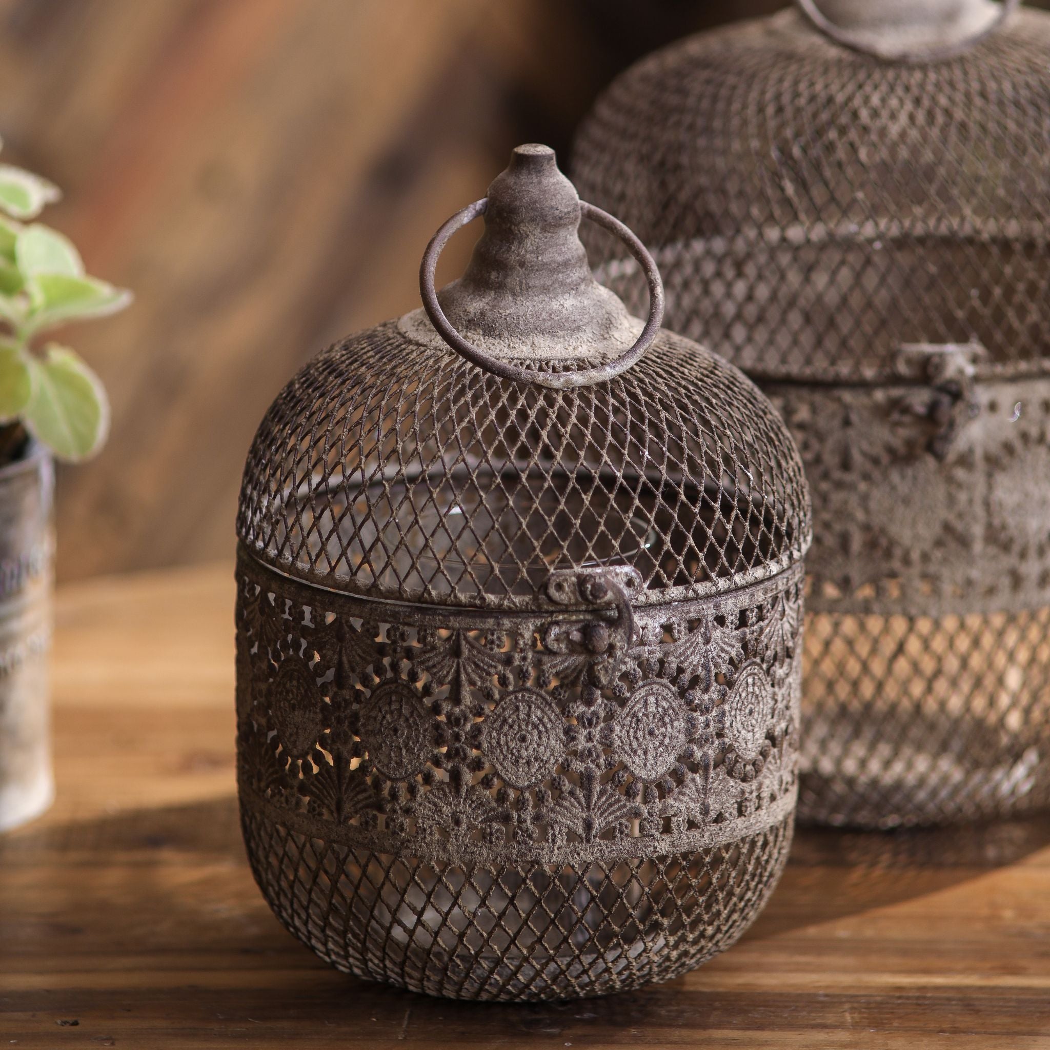 Afra aged metal lantern with sister piece Amani, lifestyle on raw wood