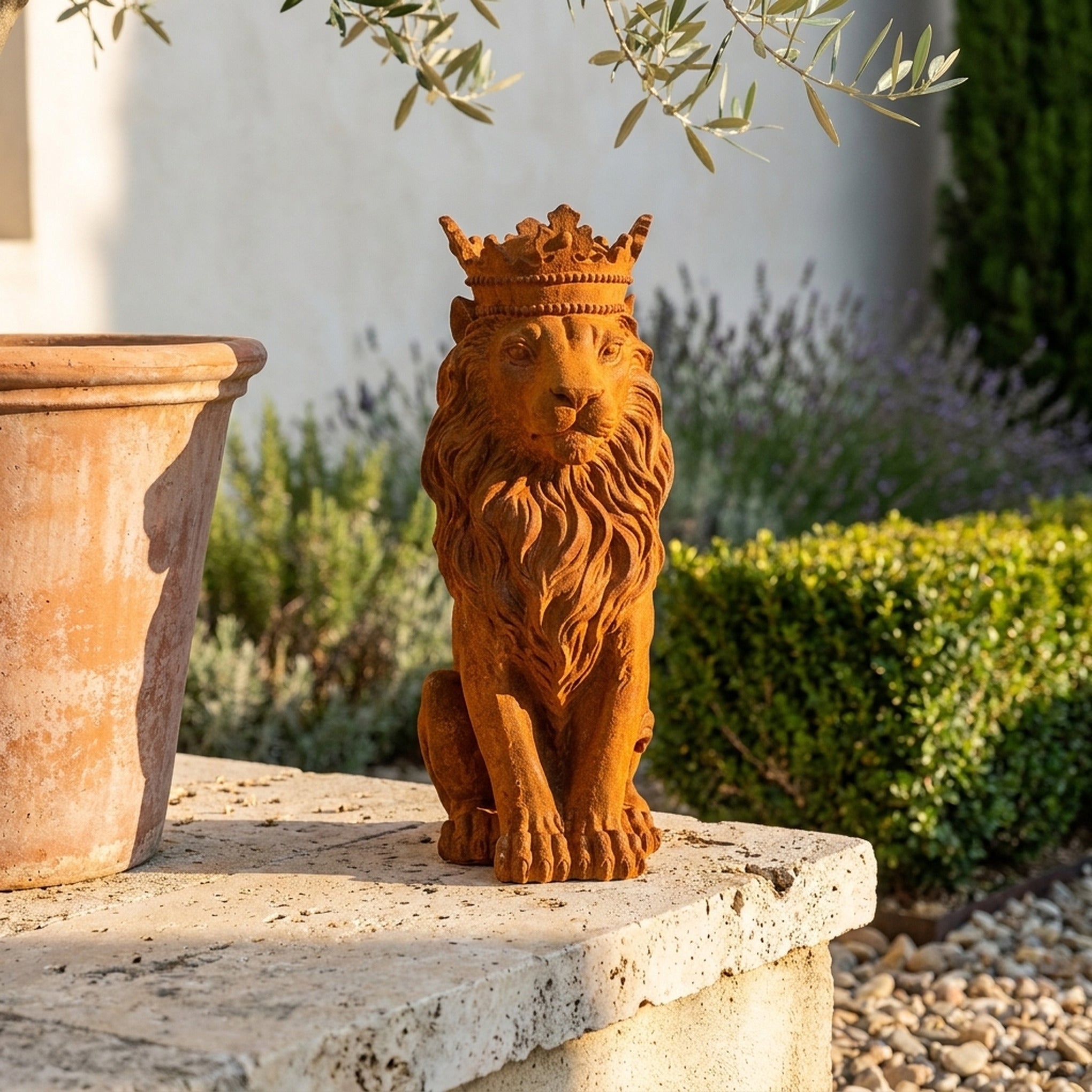 King Balthazar rust cast iron crowned lion statue on a travertine ledge beside a terracotta pot and clipped box