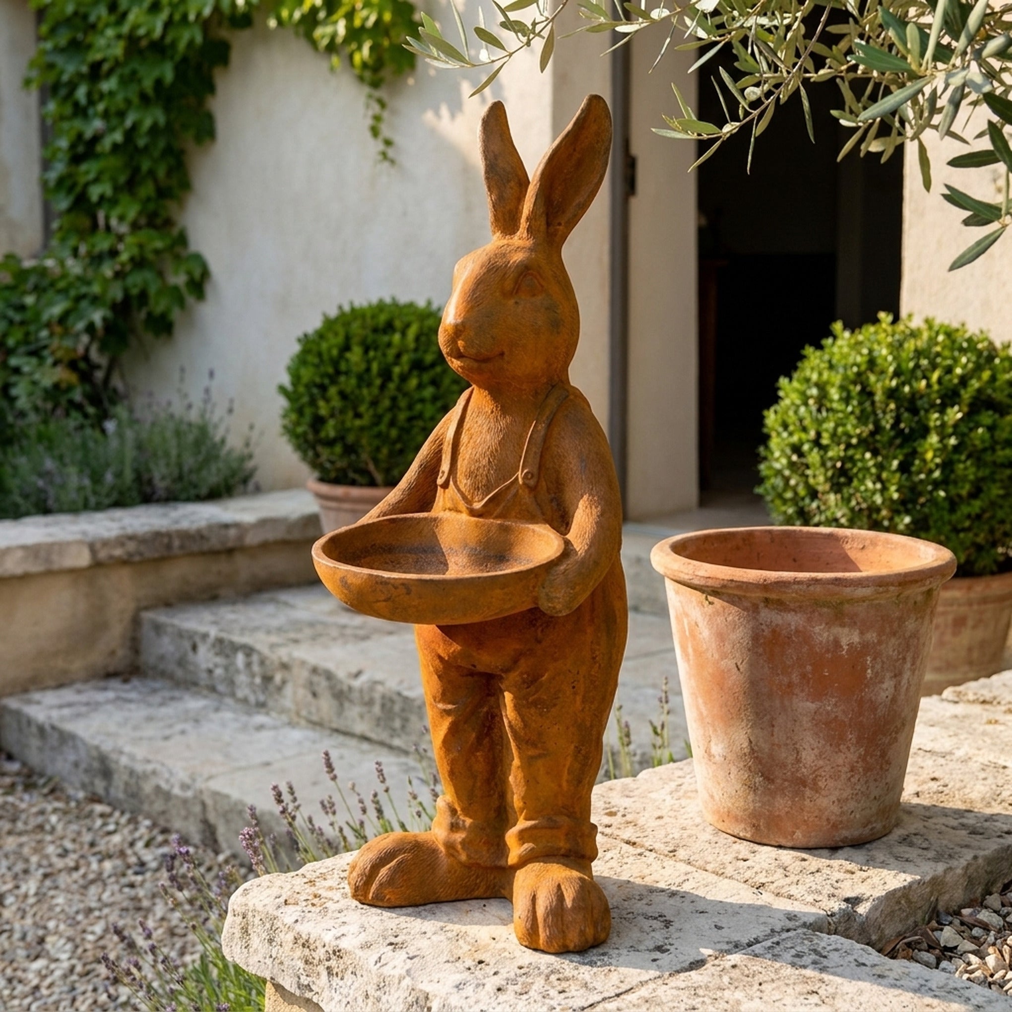 Farmer Barnaby hare statue bird feeder three quarter view in a provencal courtyard