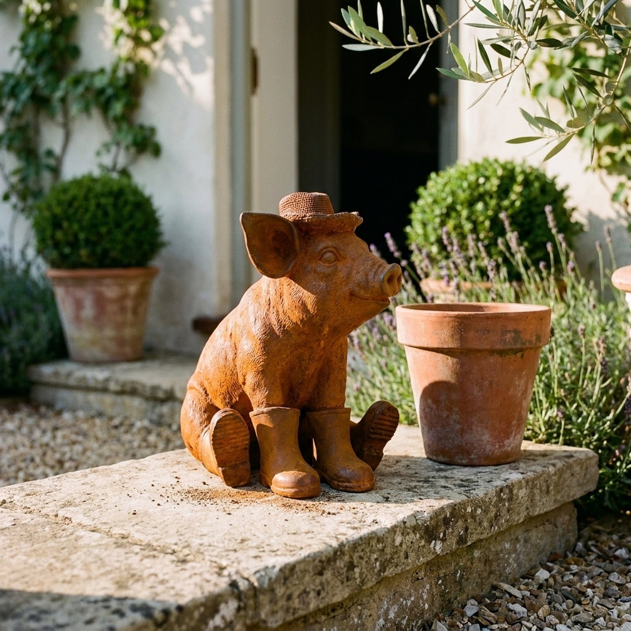 Farmer Hamish Sitting pig statue in gumboots three quarter view in a provencal courtyard