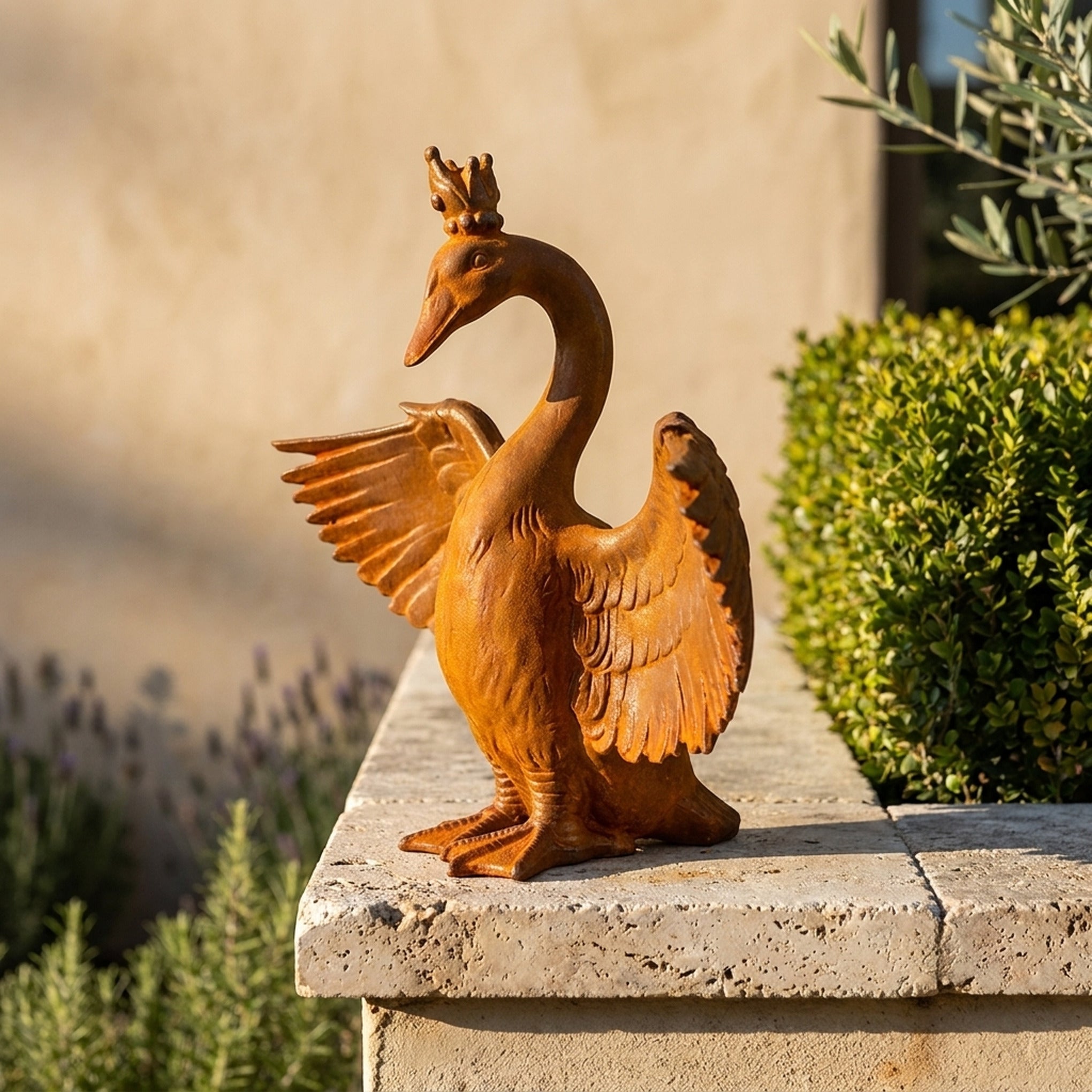 Princess Evangeline rust cast iron crowned goose statue on a travertine wall cap beside clipped box and lavender