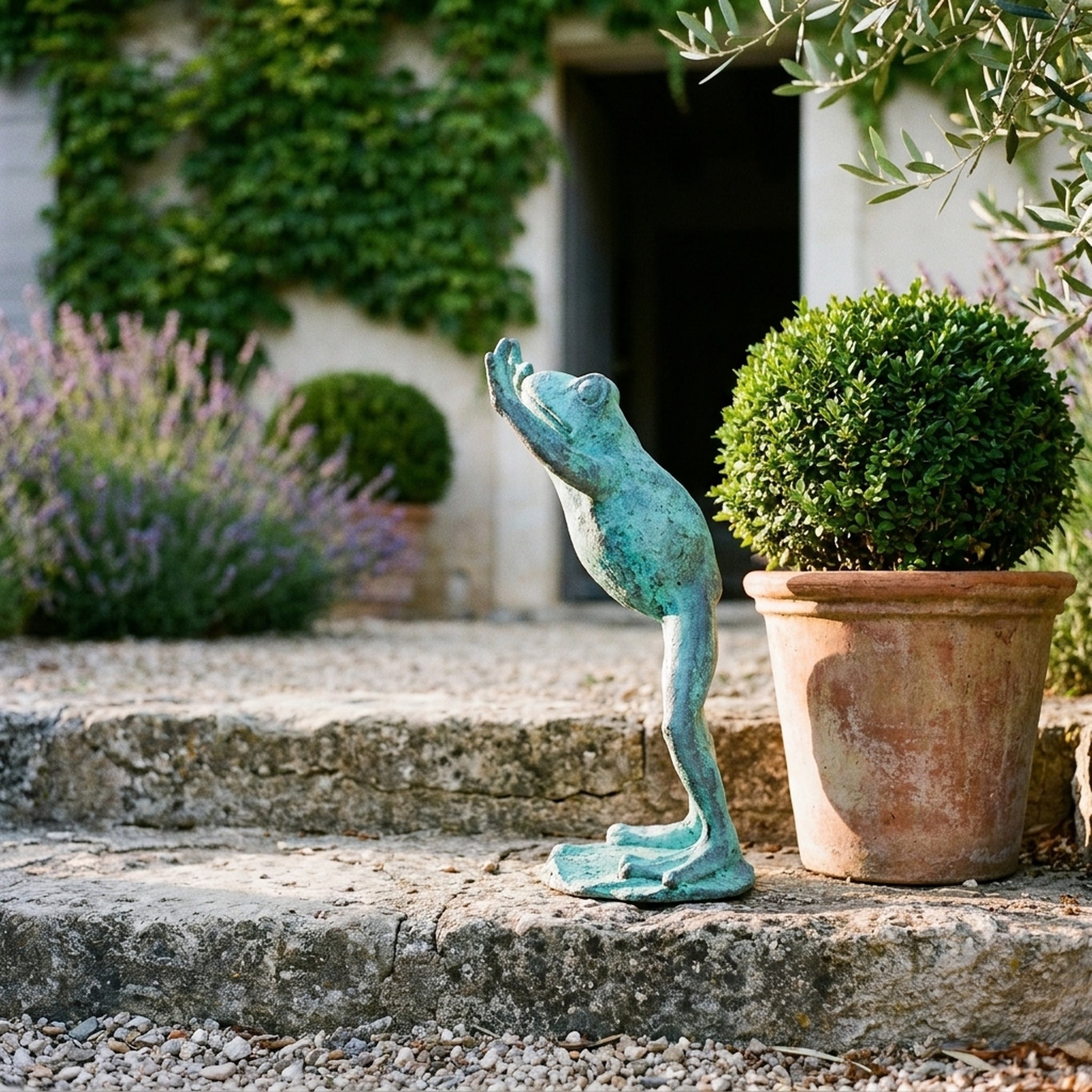 The Frog Prince Verdigris frog statue three quarter view in a provencal courtyard