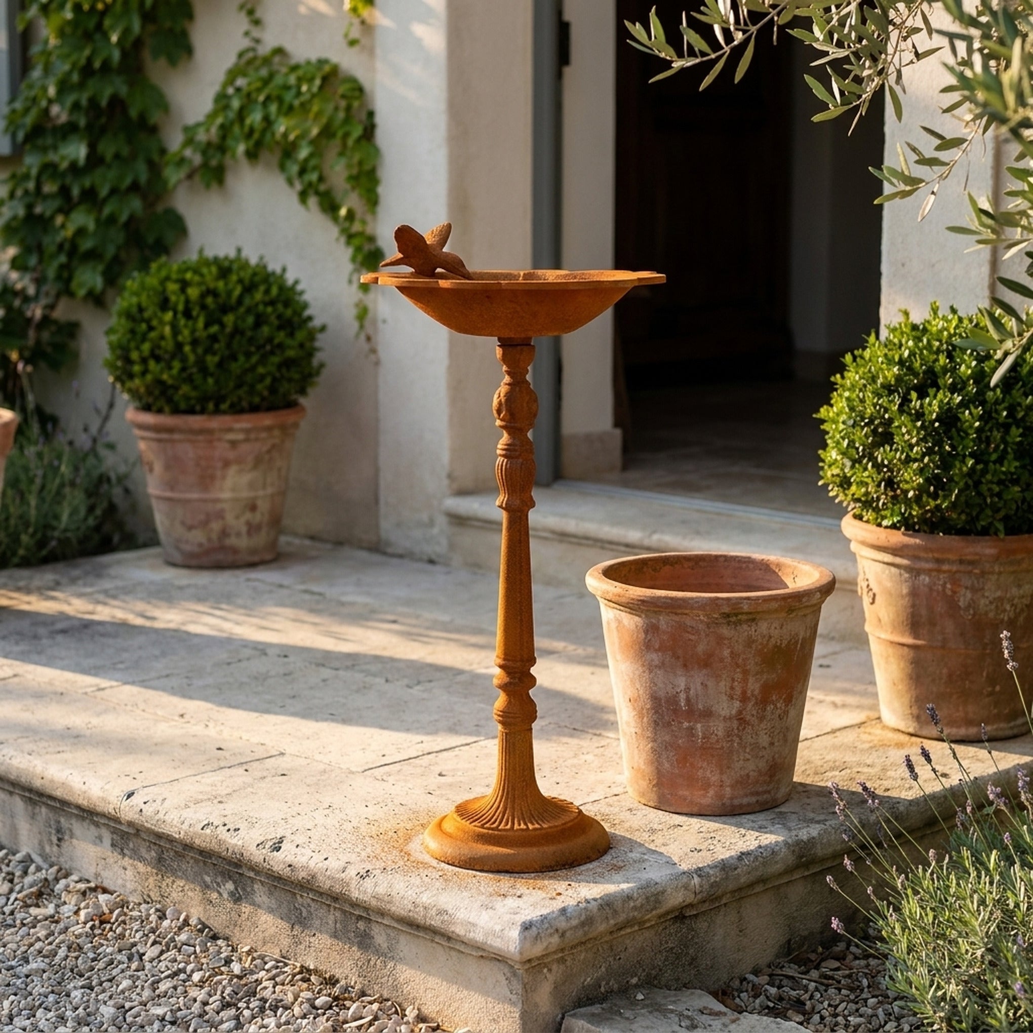 The Willowmere pedestal bird bath three quarter view in a provencal courtyard