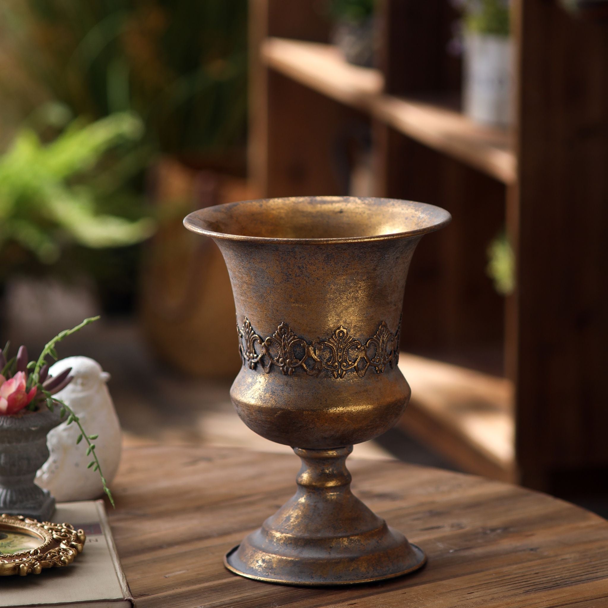 Magda antique gold pedestal urn standing empty showing the flared rim and embossed band