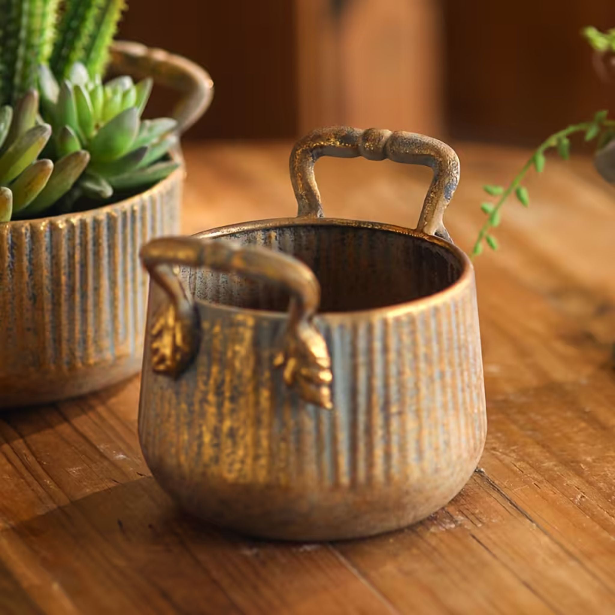 Milo small pot close-up of the ribbed texture and worn gold over grey