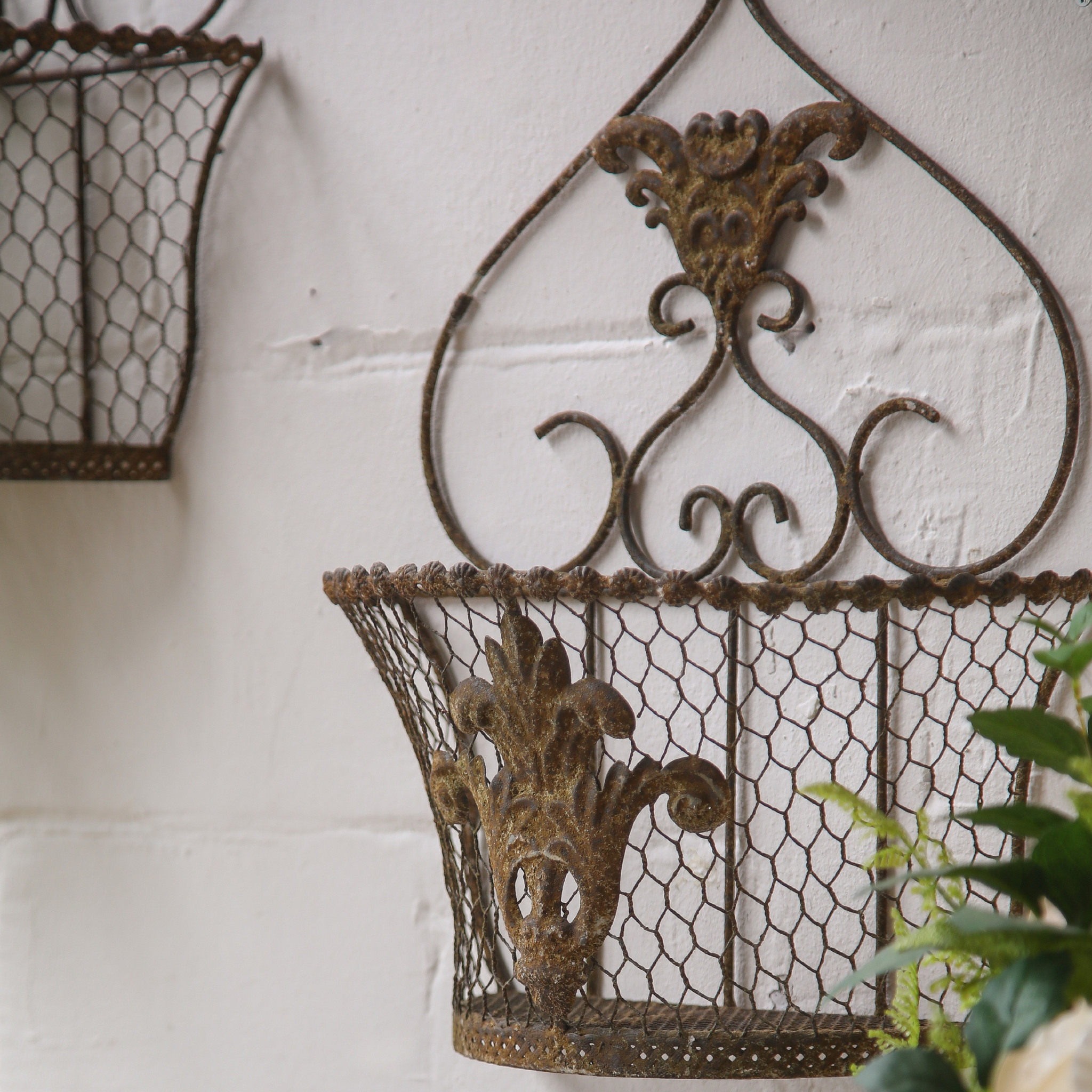 Como wall basket close view of the pressed metal crest and scrollwork