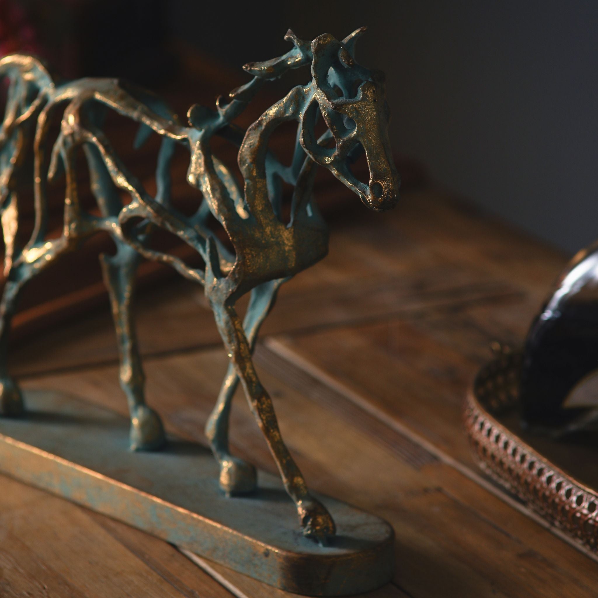 Close-up of the head and neck of the Jules sculpture, gold finish over green verdigris