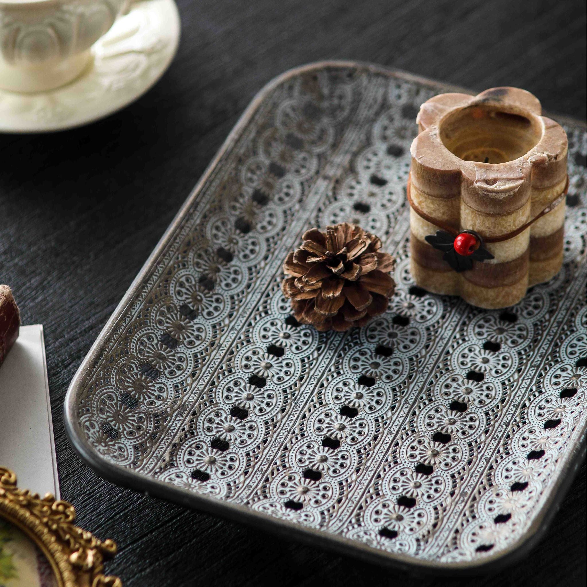 Single large Adélaïde metal tray styled with a candle and pinecone, full pierced lace pattern across the base