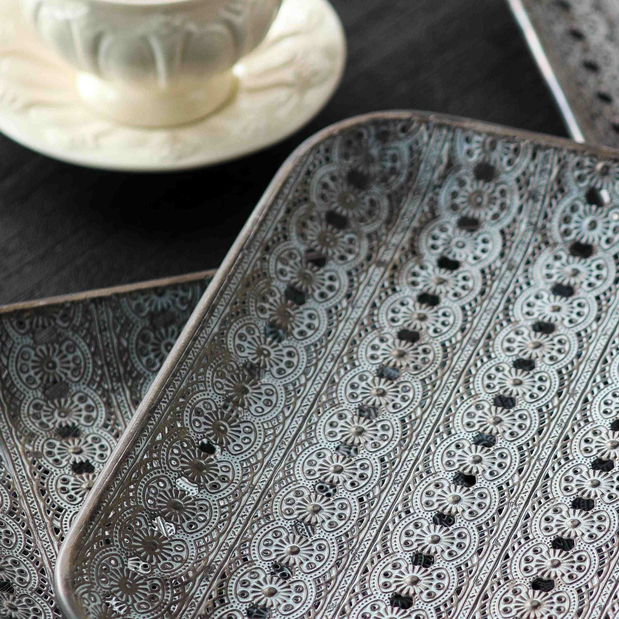 Close detail of an Adélaïde tray corner showing the embossed floral medallions and pierced lace openings