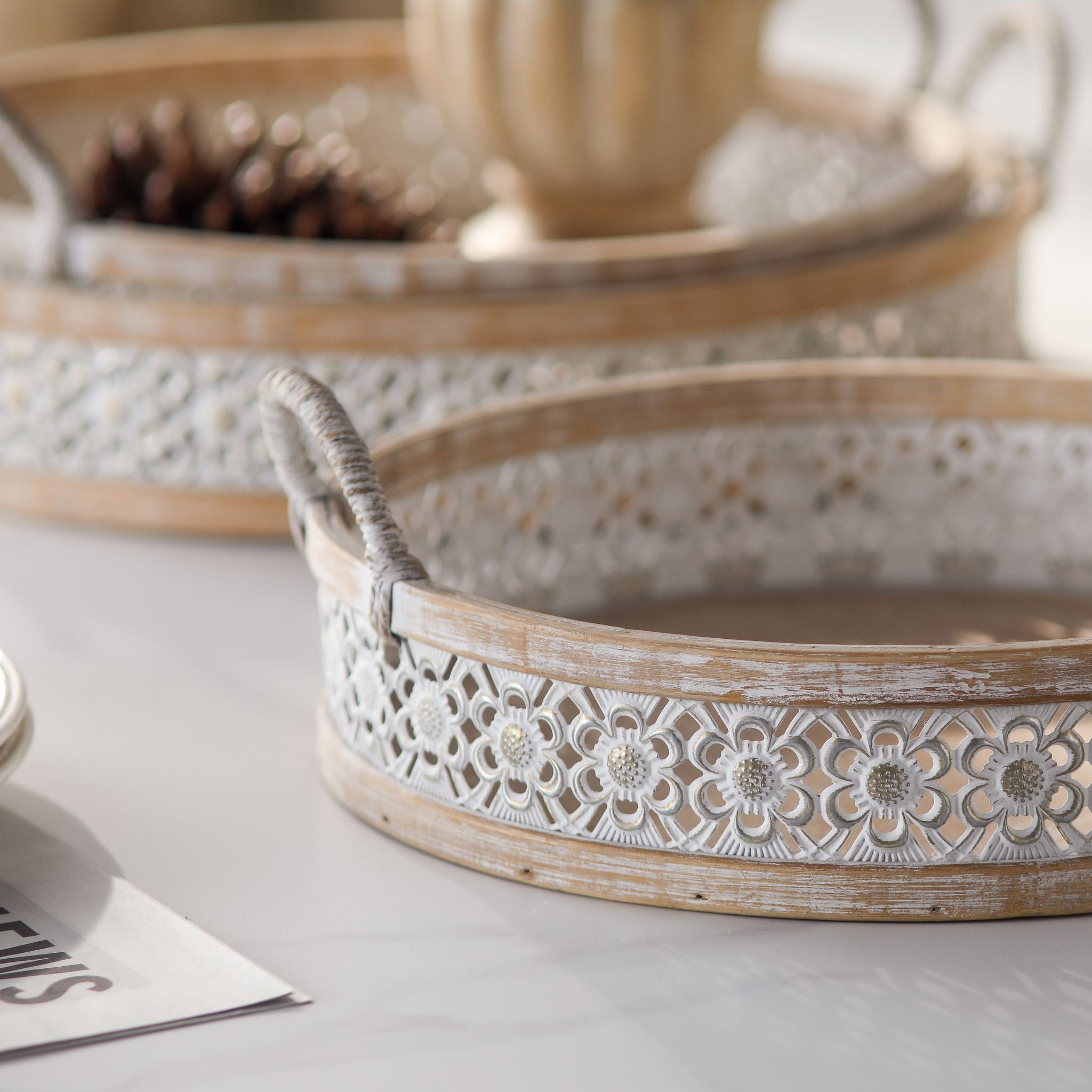 Detail of the Alexandrine trays pierced floral metal band and whitewashed wood frame