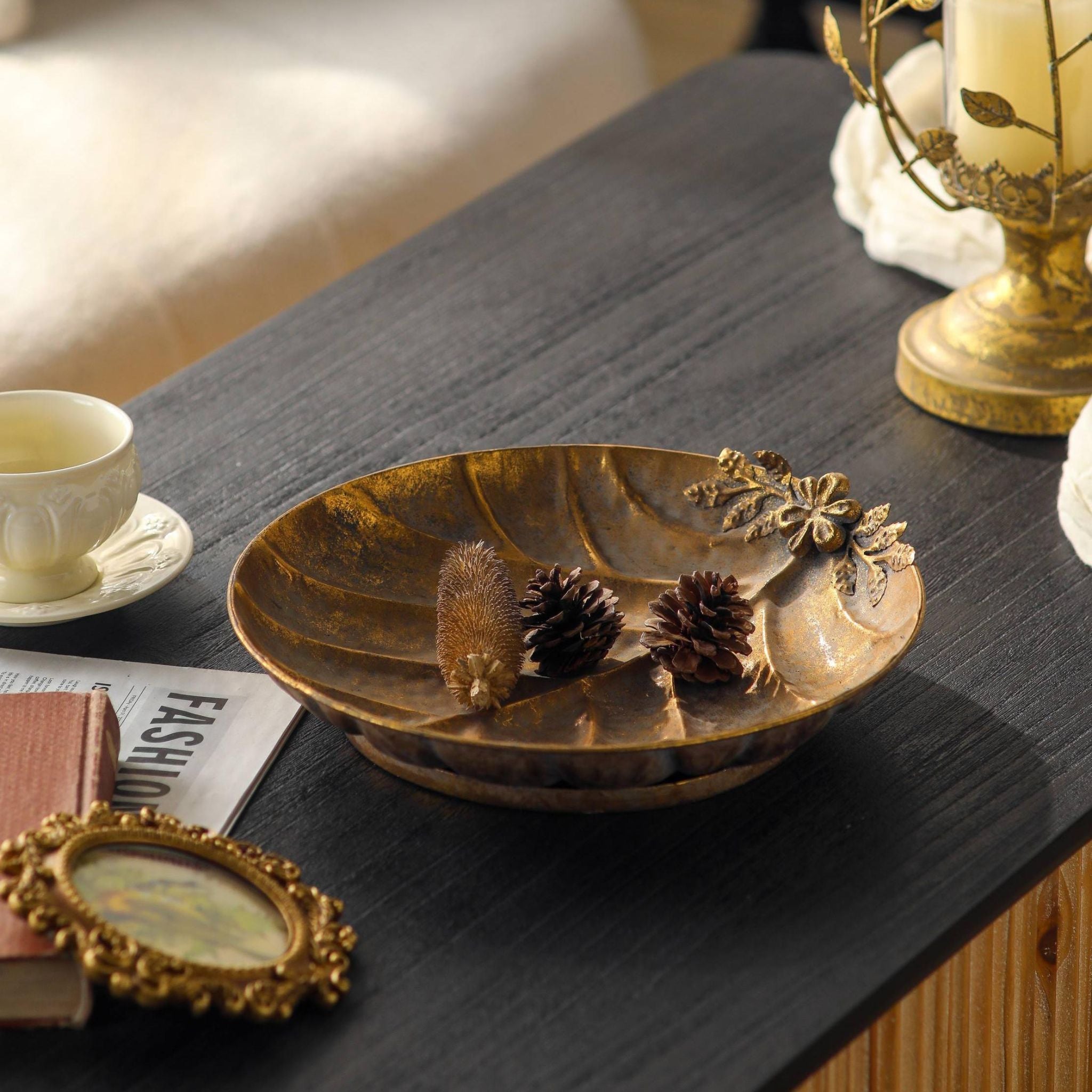 Alida leaf dish at an angle showing the low footed base, styled with pinecones and a dried banksia