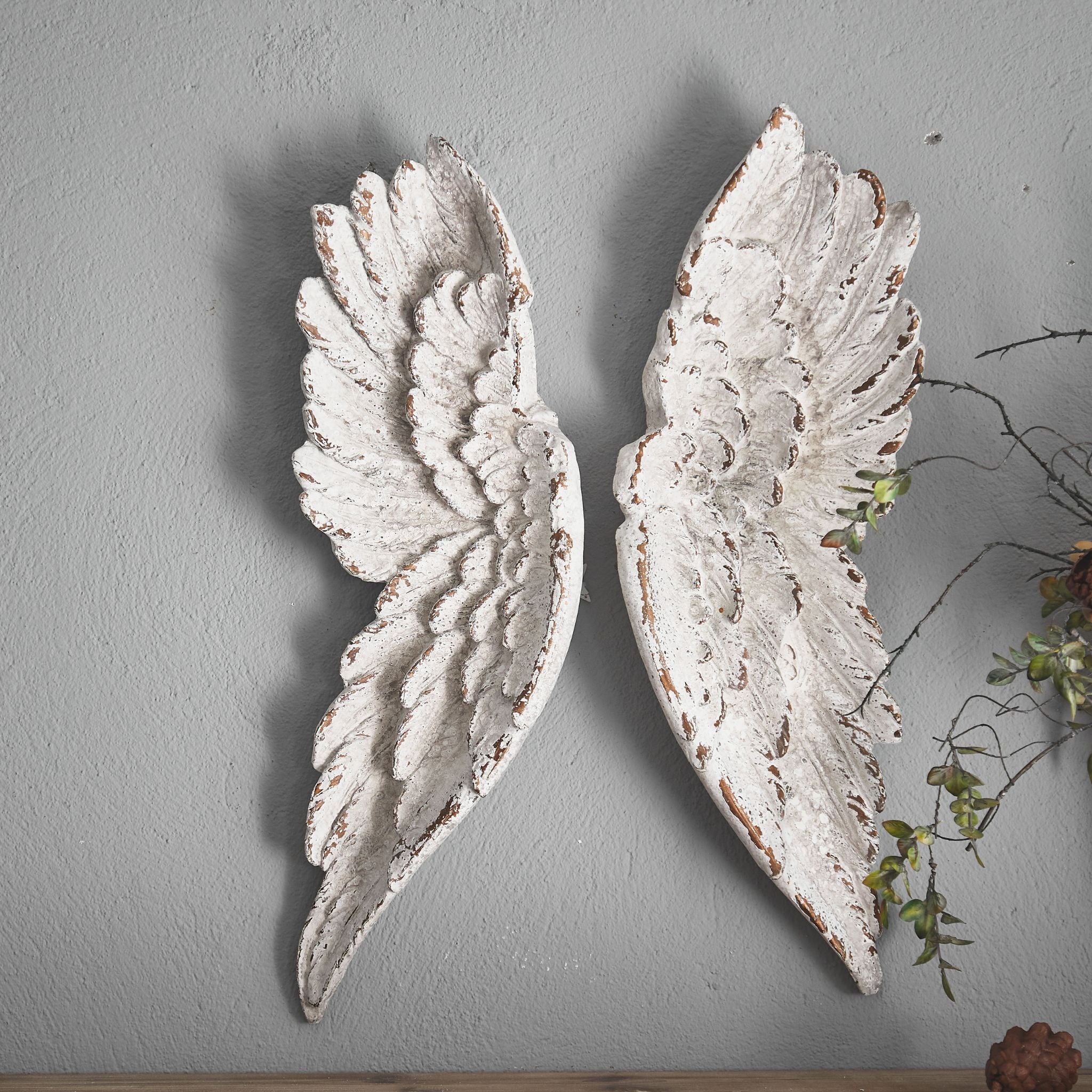The Alora angel wings styled on a wall above a wooden shelf in a French country room.