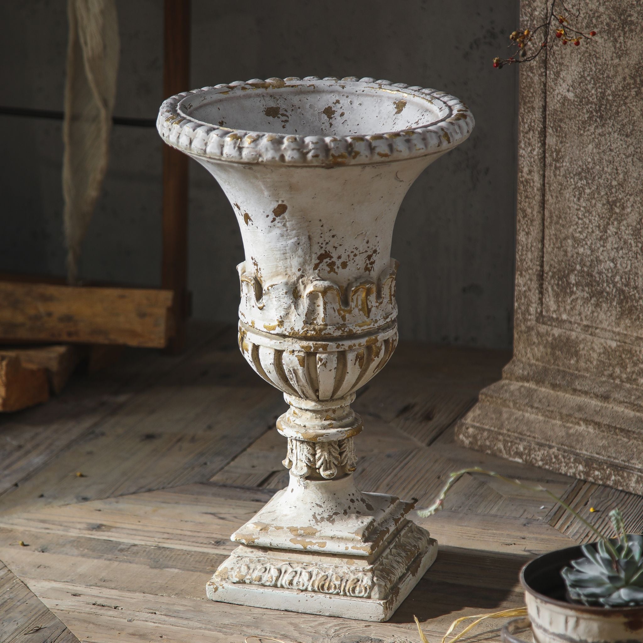 Anaïs trumpet urn planter front on, beaded rim, lambrequin band, gadrooned bowl and square plinth in antique white worn to gilt.