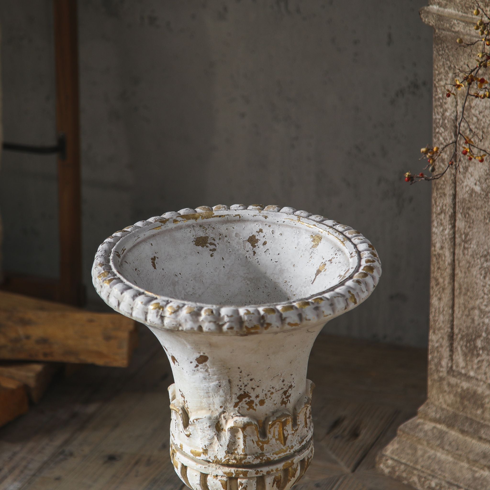 Close-up of the Anaïs urn trumpet rim and lambrequin band, antique white worn back to a gilt-toned undertone.