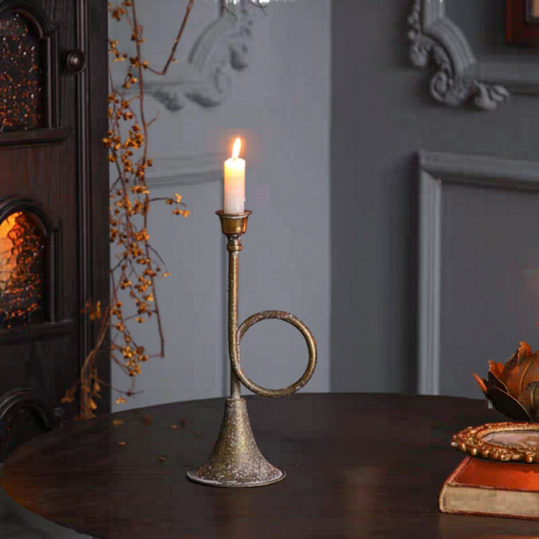Renée horn candle holder lit with a white taper in a French country interior.