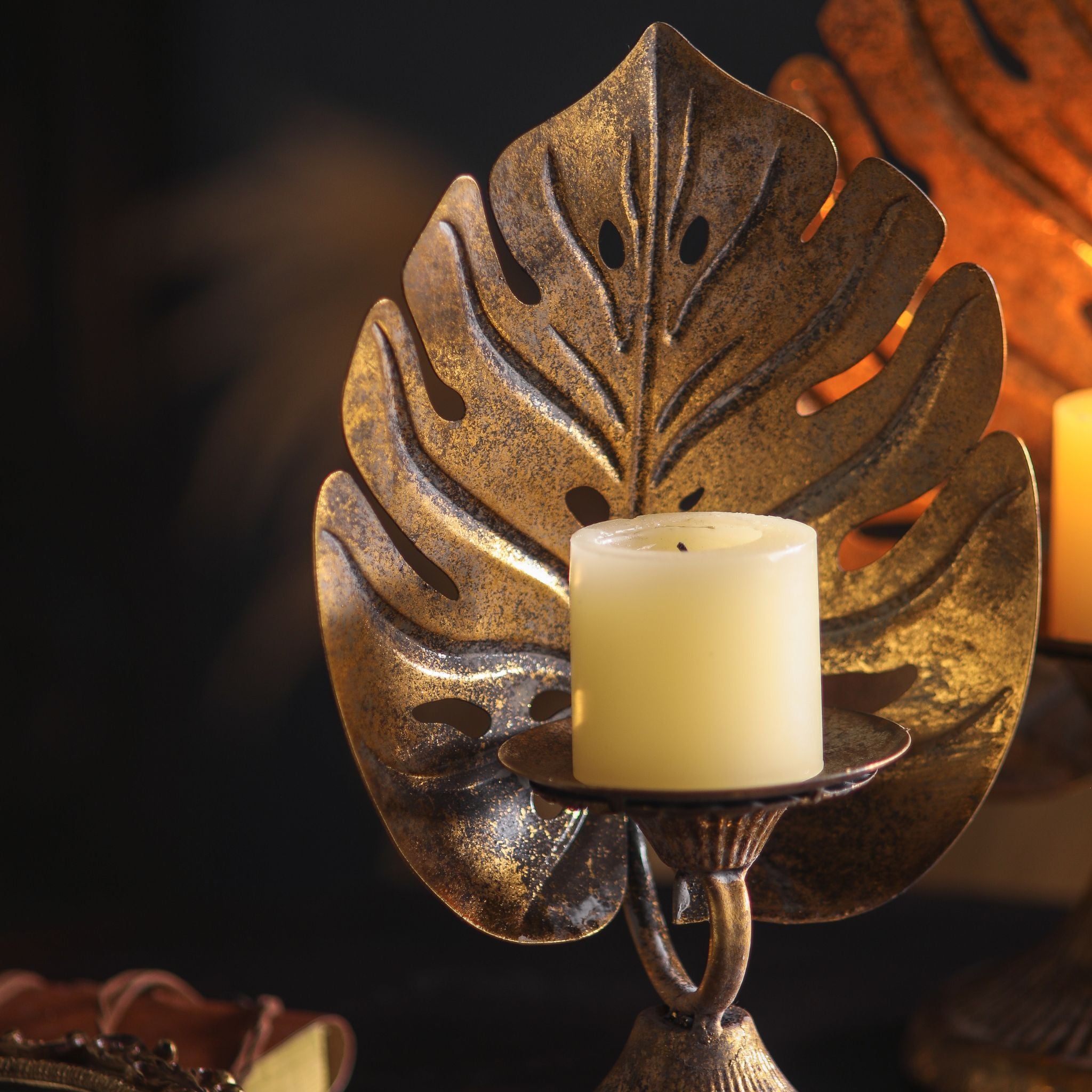 Close-up of the candle dish, scroll connector, and fluted base, mottled antique gold finish.