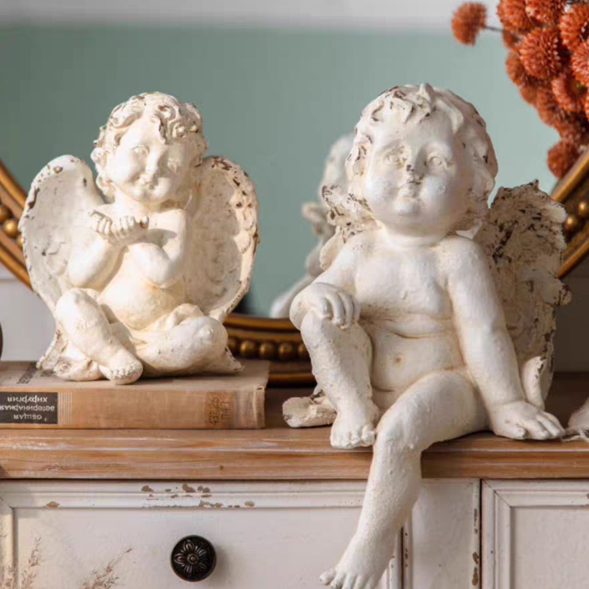 Antoine cherub figurine on the right with the smaller Élodie cherub on the left, shown for scale on a layered dresser setting
