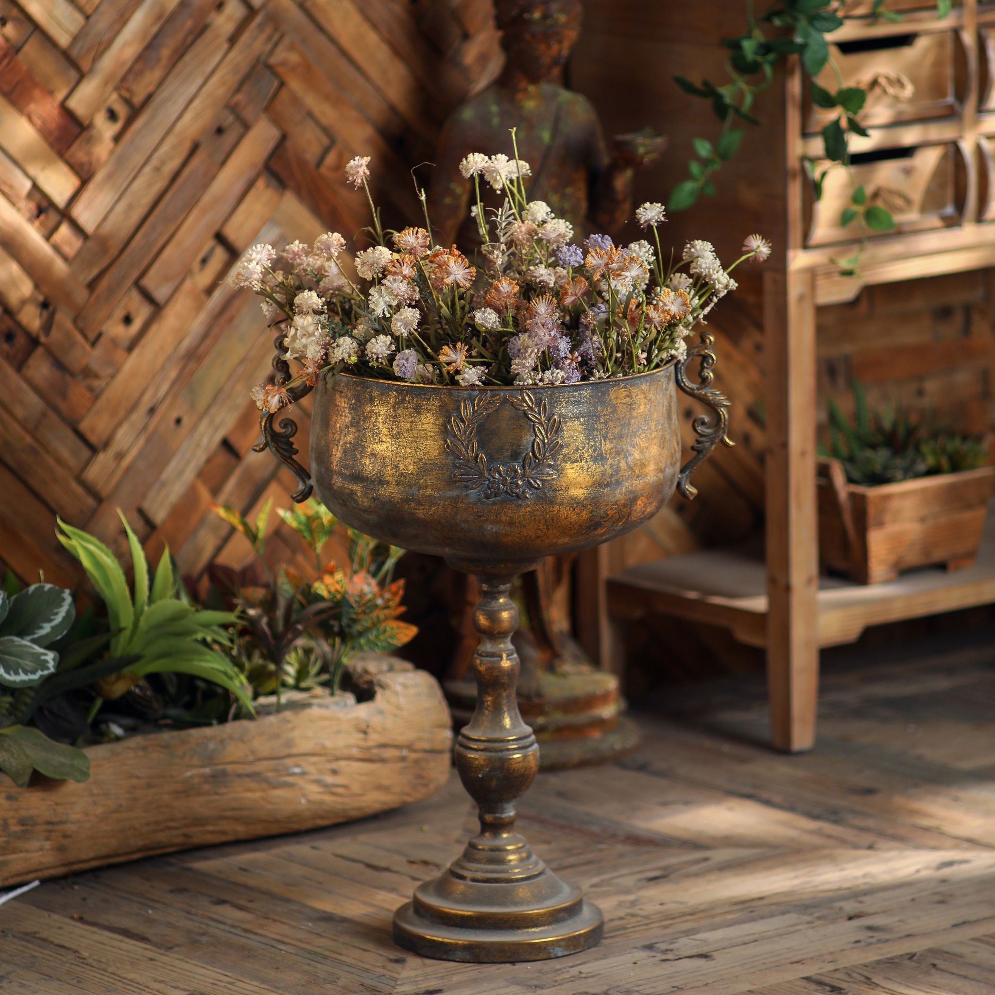 Antique gold footed urn planter with scroll handles filled with dried wildflowers, French Provincial styling on a timber floor