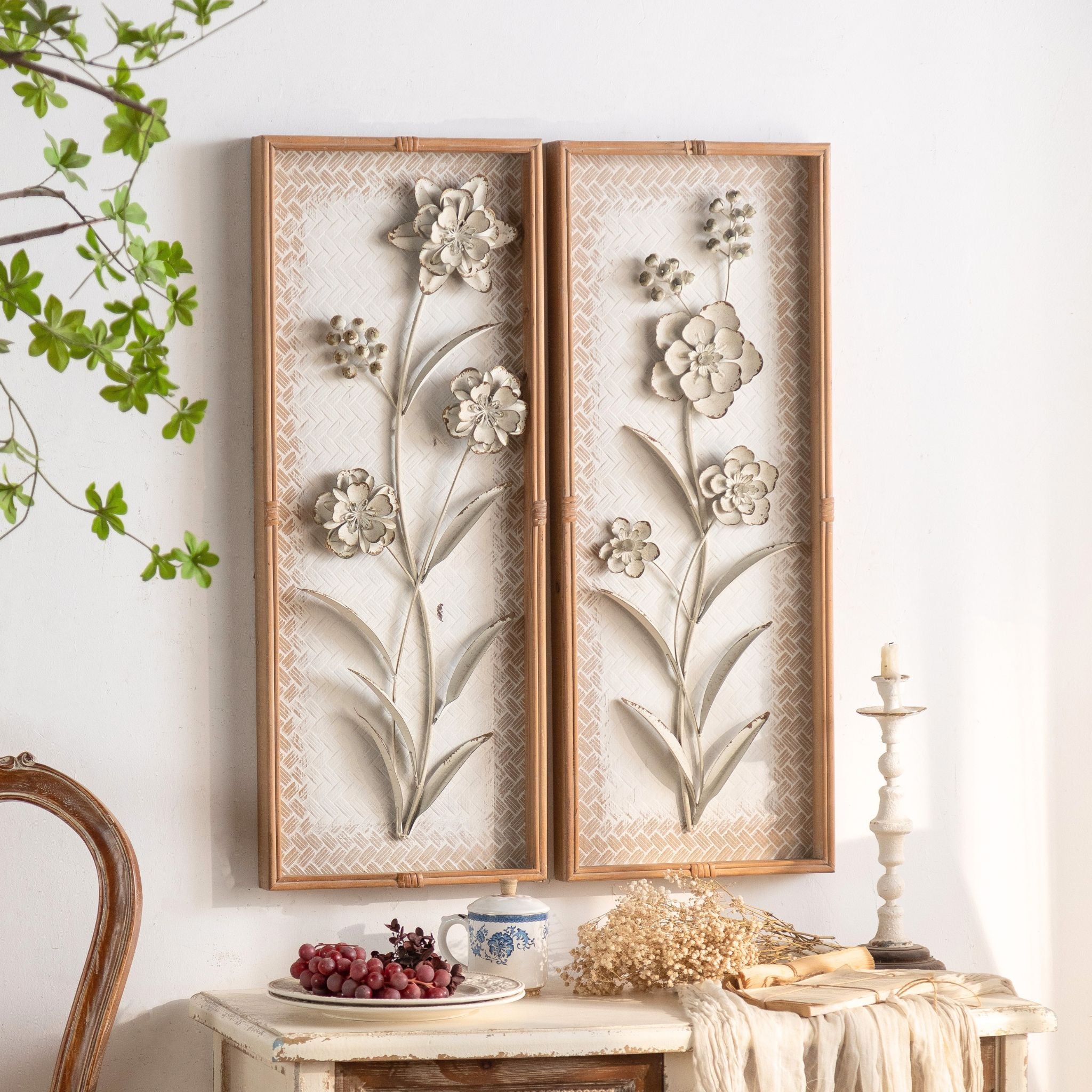 Aurélien French Provincial botanical wall art, a pair of panels with raised distressed-metal flowers on a woven bamboo ground in natural bamboo frames.