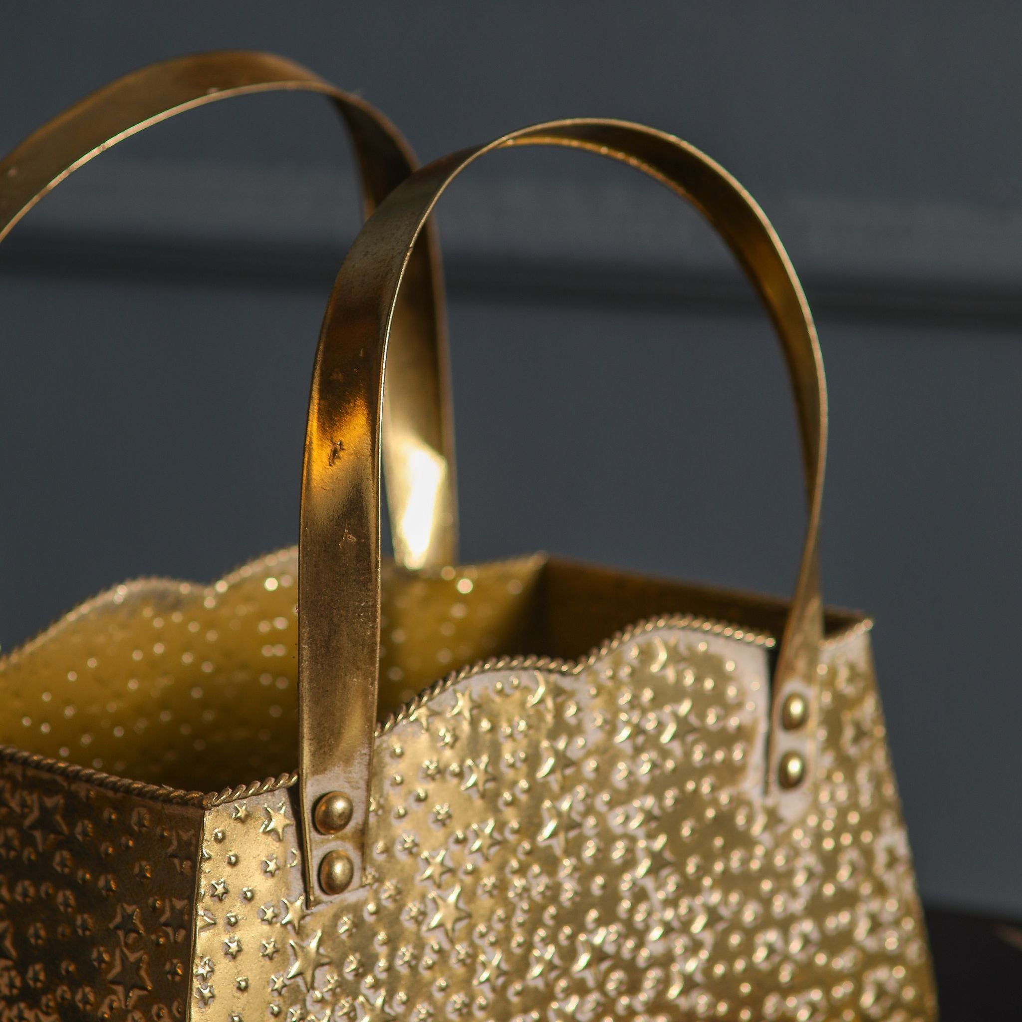 Arched strap handles riveted with round studs on the antique gold handbag planter
