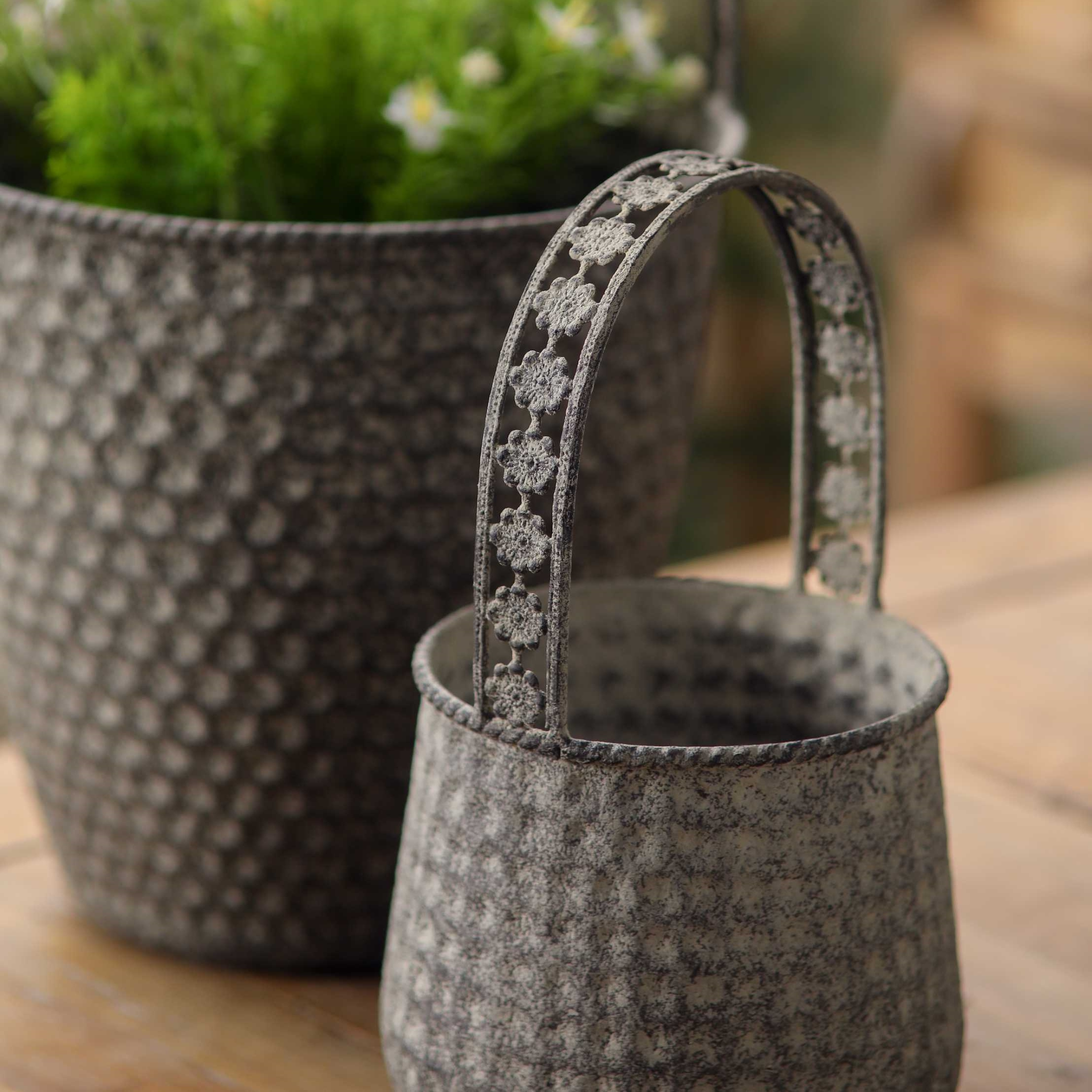 Close-up of the flower-pierced handle and mottled grey finish on the Bernadette baskets