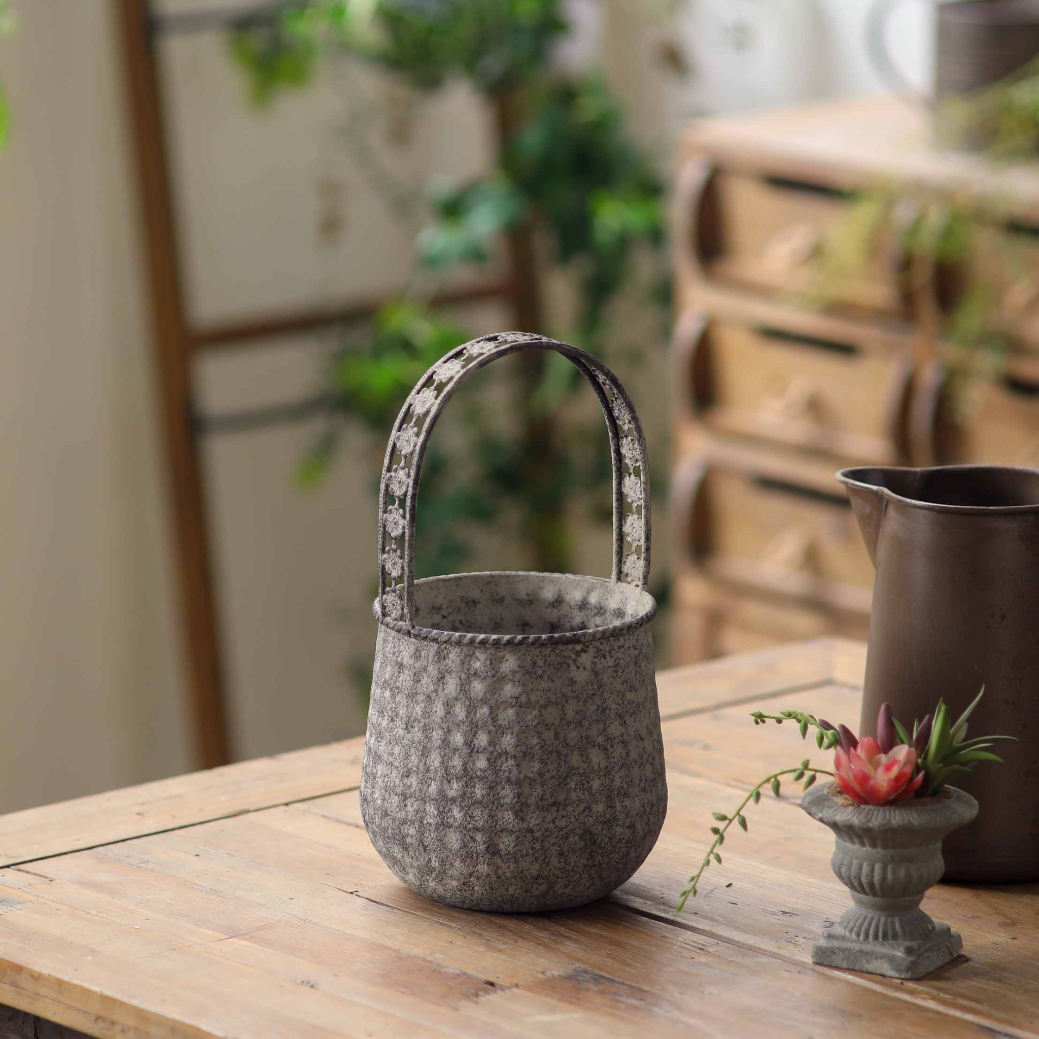 The smaller Bernadette basket planter empty, showing the dimpled texture and flower handle