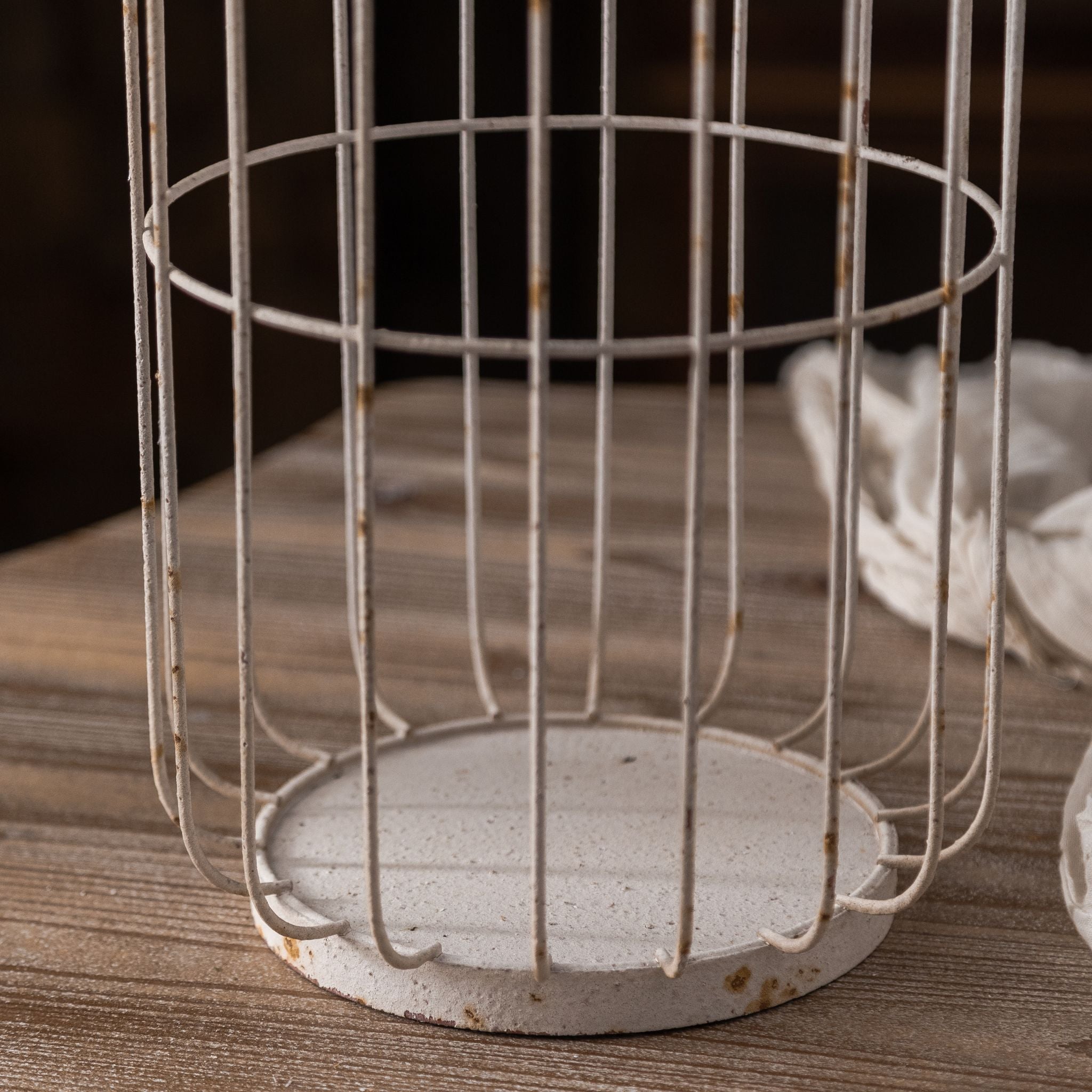 Bernard birdcage candle lantern round metal base showing antique white finish with rust patina