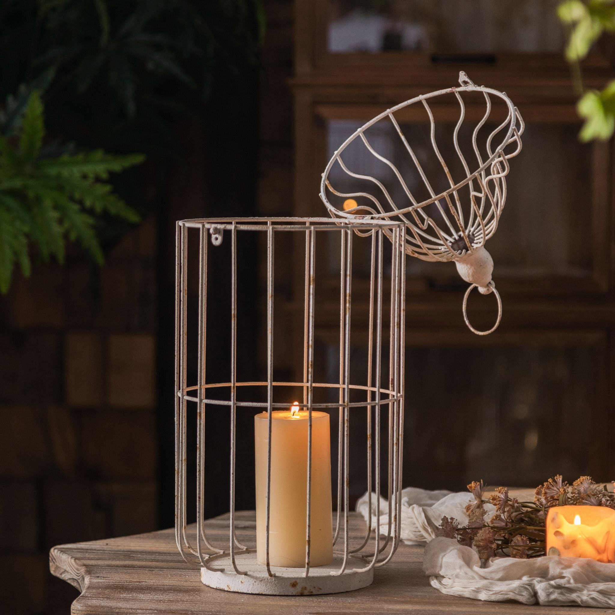 Bernard large birdcage candle lantern open at the dome with lit pillar candle inside