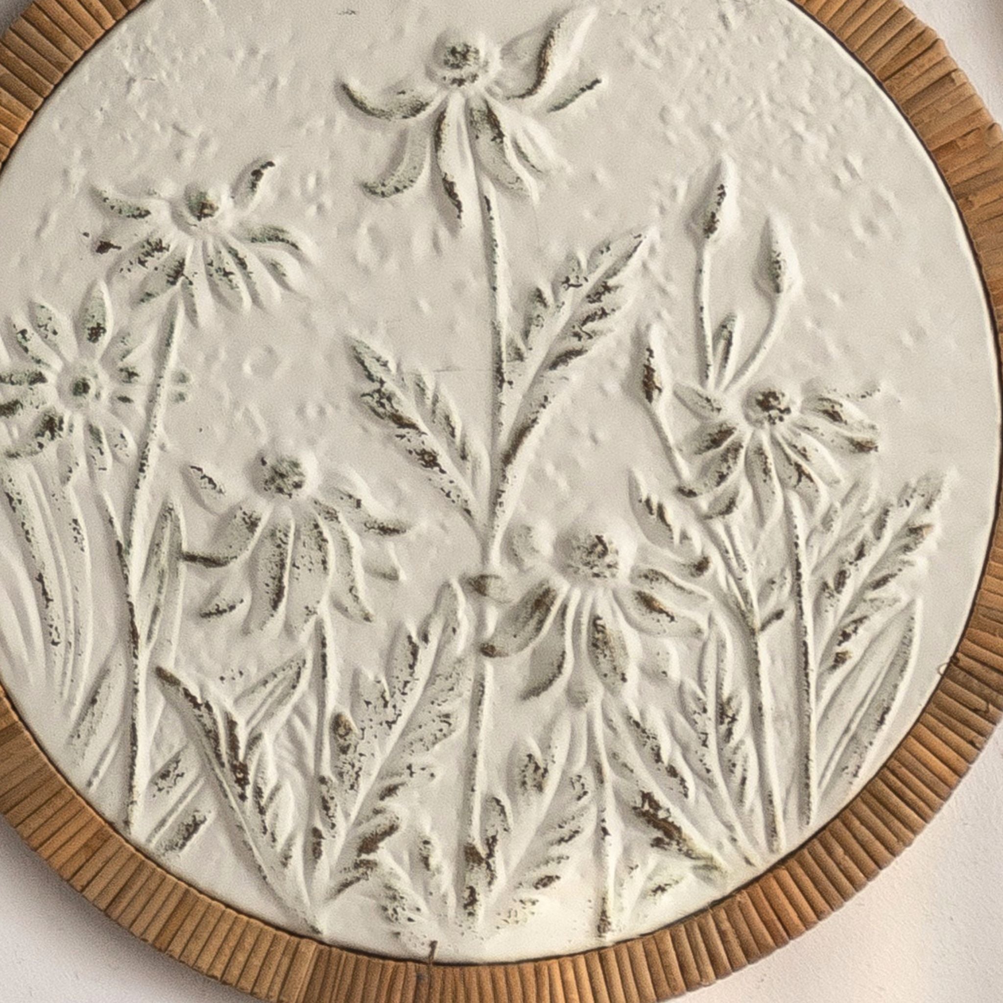 Close-up of the embossed meadow relief on the Calvin panel, distressed white with aged tones.