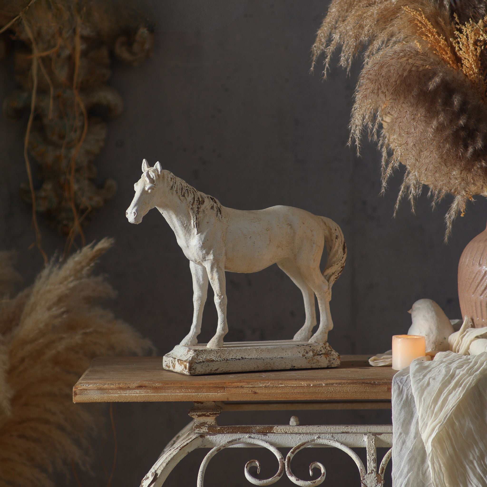 Camargue horse sculpture side profile showing the full standing figure on its plinth, aged cream finish with subtle rust undertones.