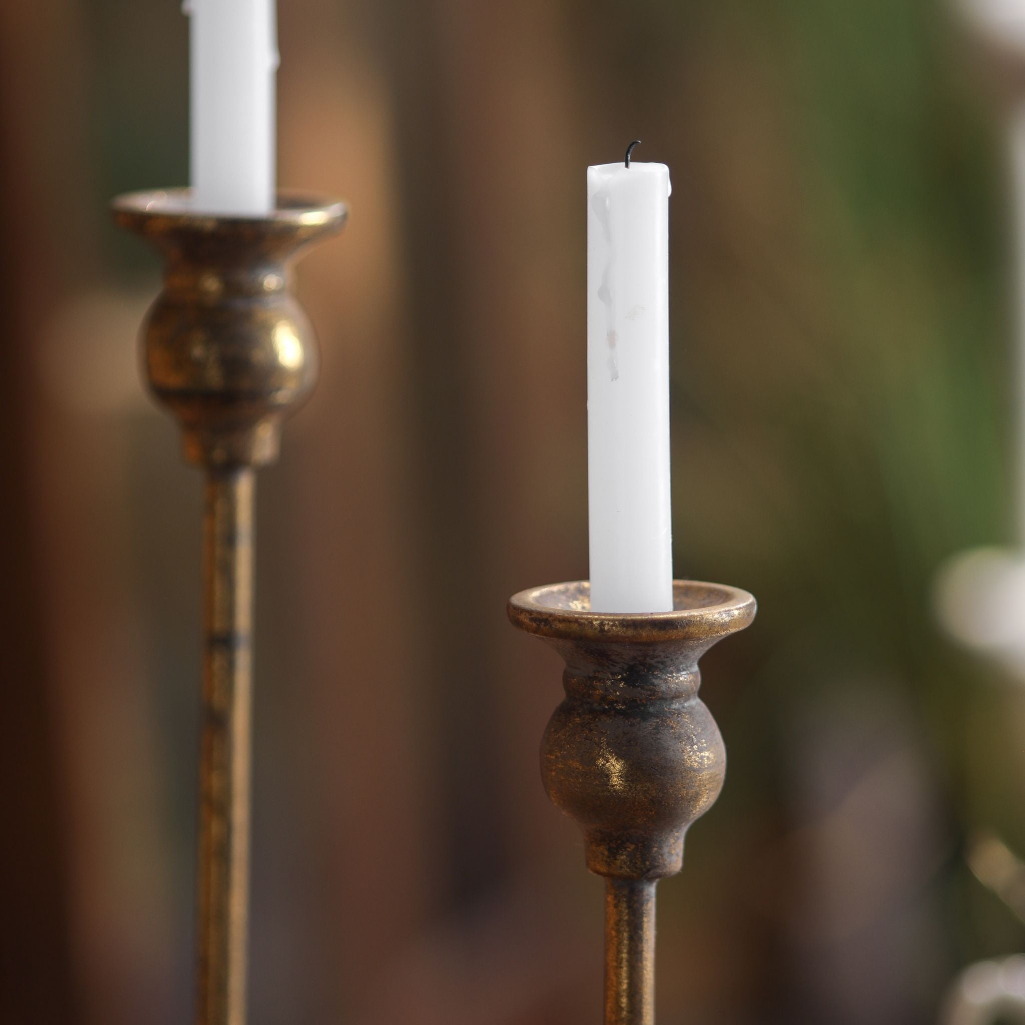 Close-up of the Karine taper candlestick candle cups and urn-shaped knop in aged gold metal