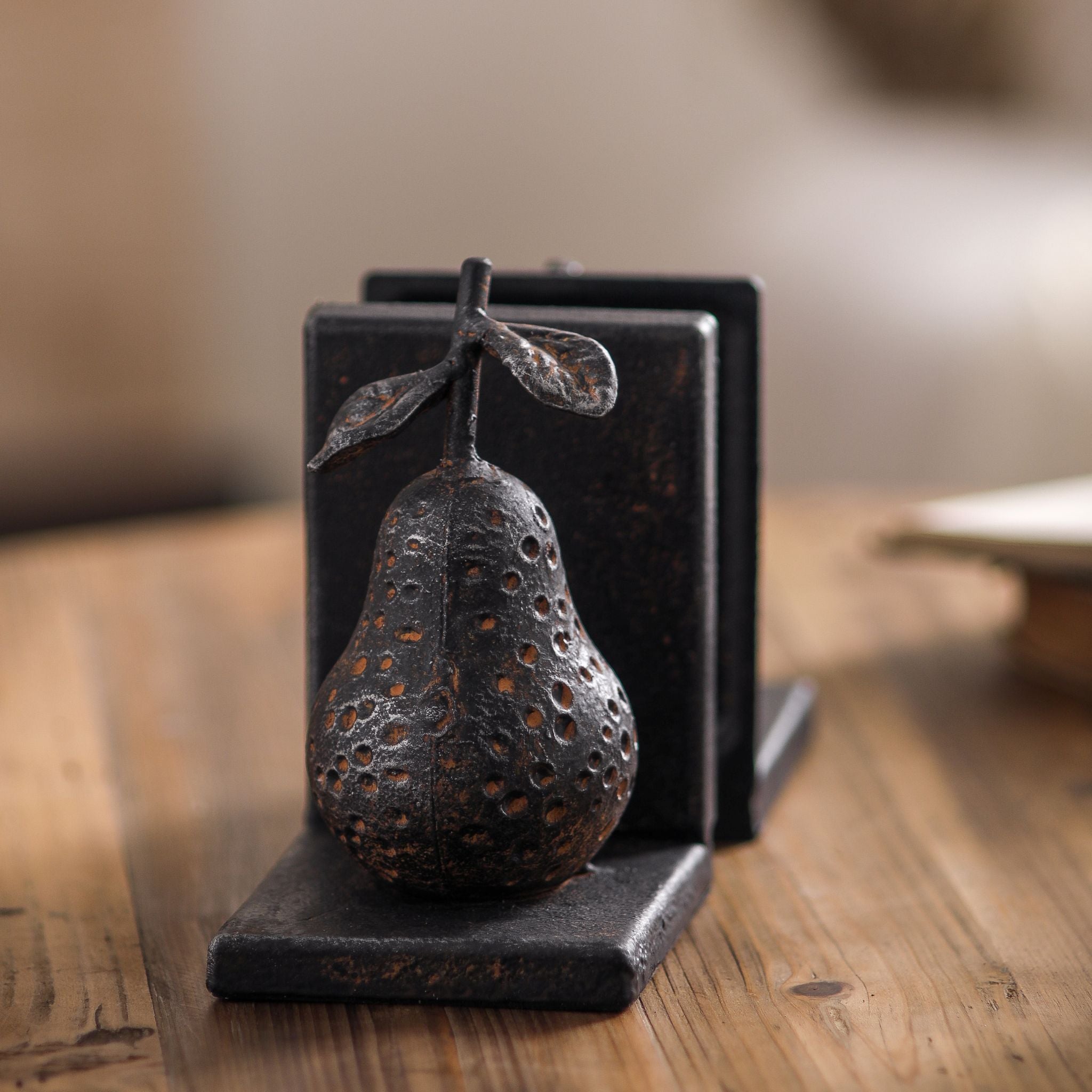 The Poire pear and apple cast iron bookends facing each other, showing both fruit shapes.