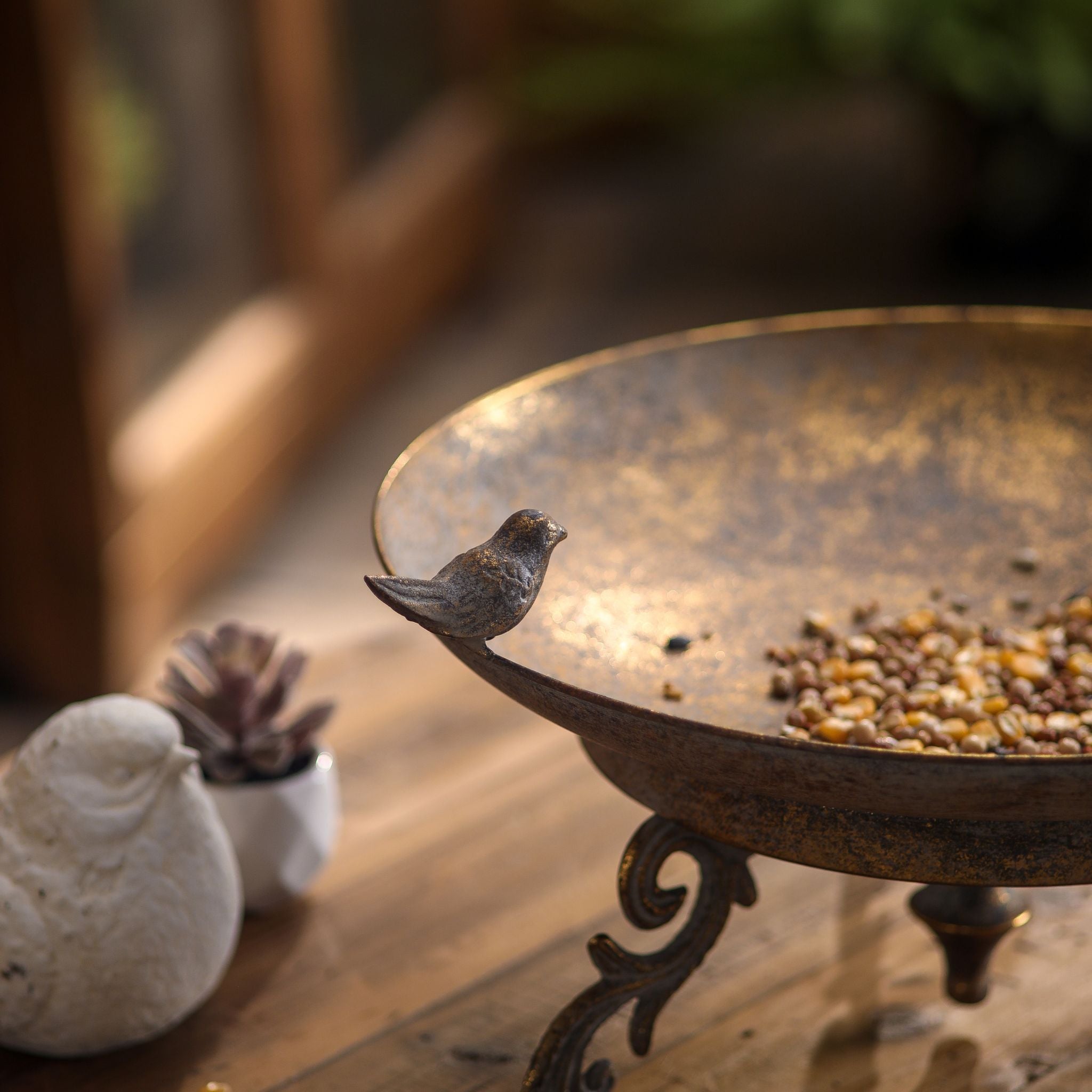 Detail of a single bird figure on the rim and one scrolled foot of the Chandler dish.