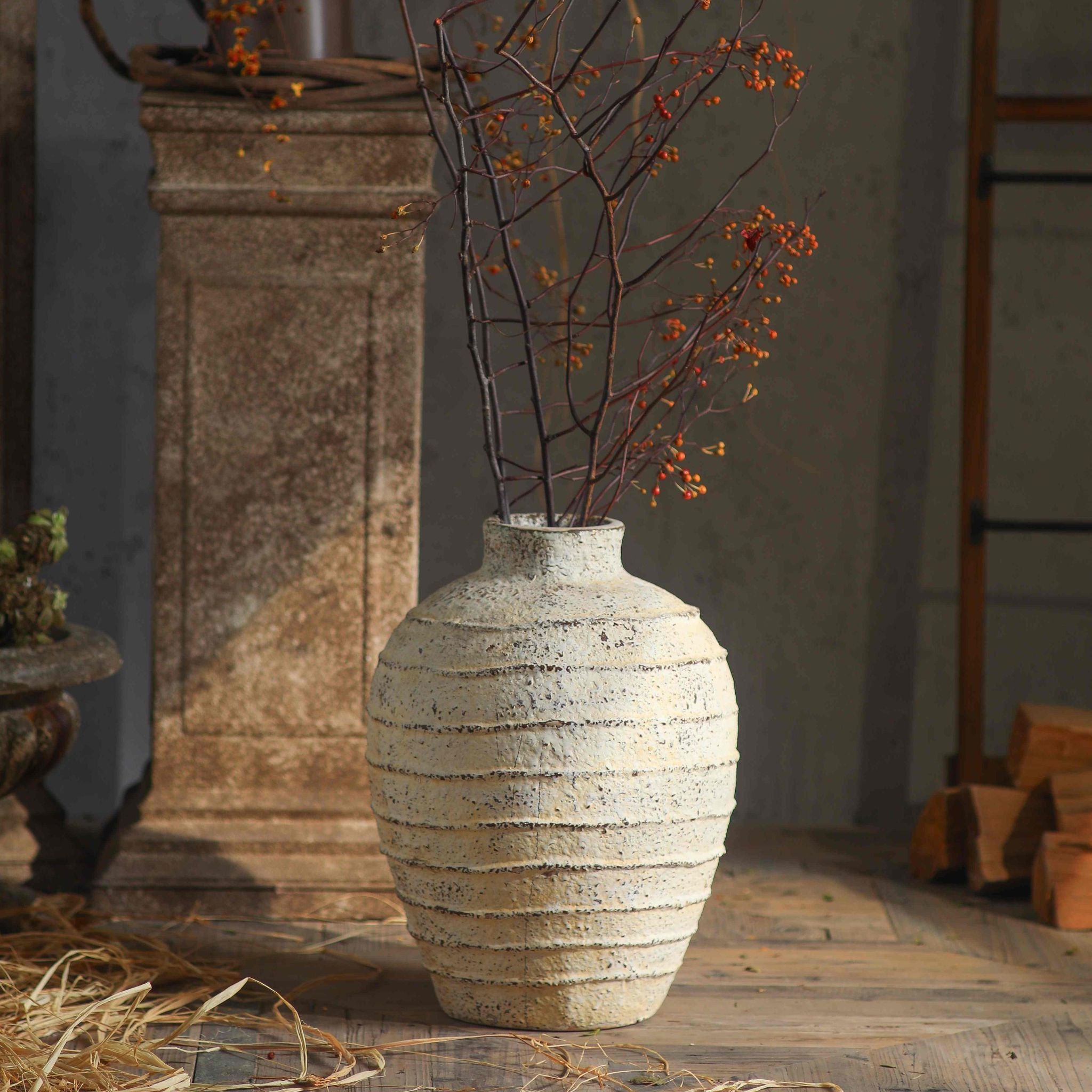 Charles ribbed vase styled with berry branches beside a stone pedestal