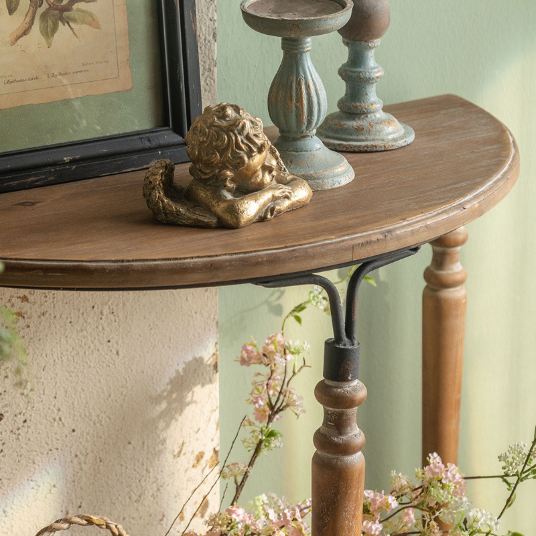 Close-up of the Clémence console showing the matte black iron arch joining the walnut leg to the natural fir top.