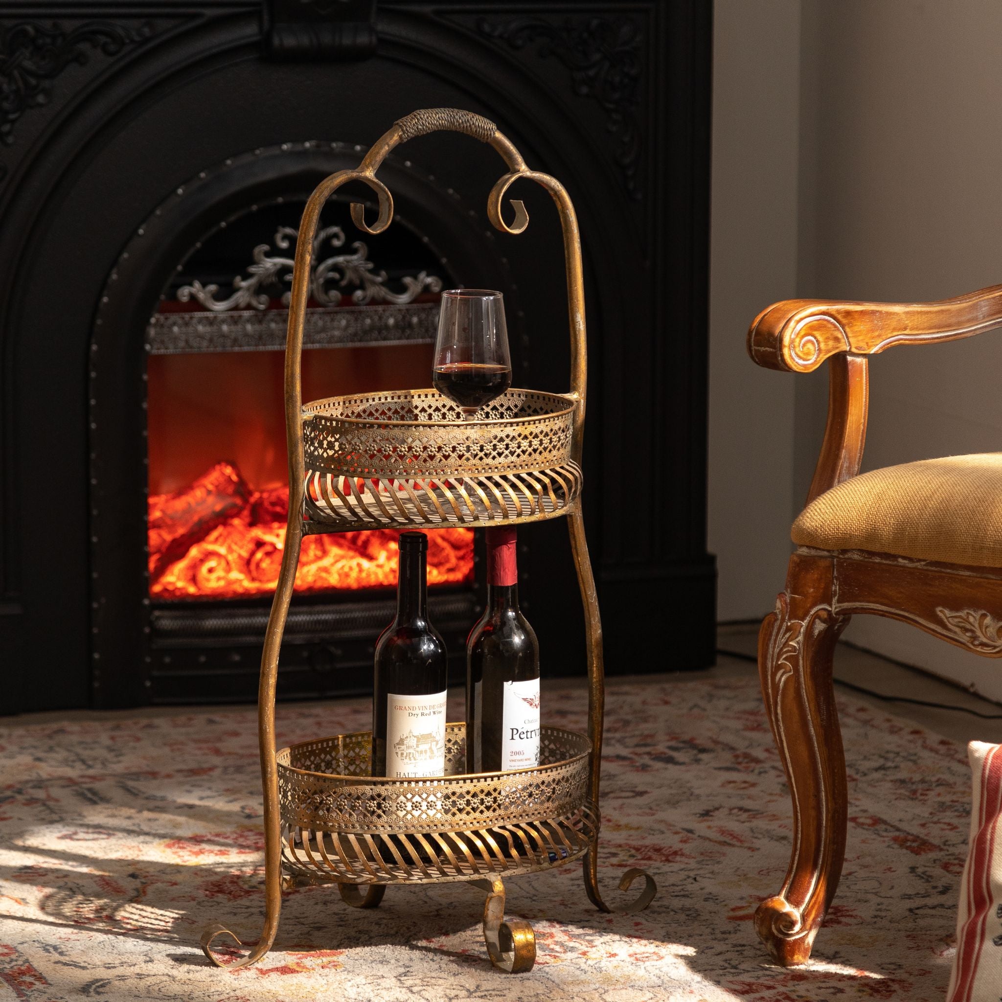 French Provincial two tier drinks stand in antique gold metal beside a fireplace