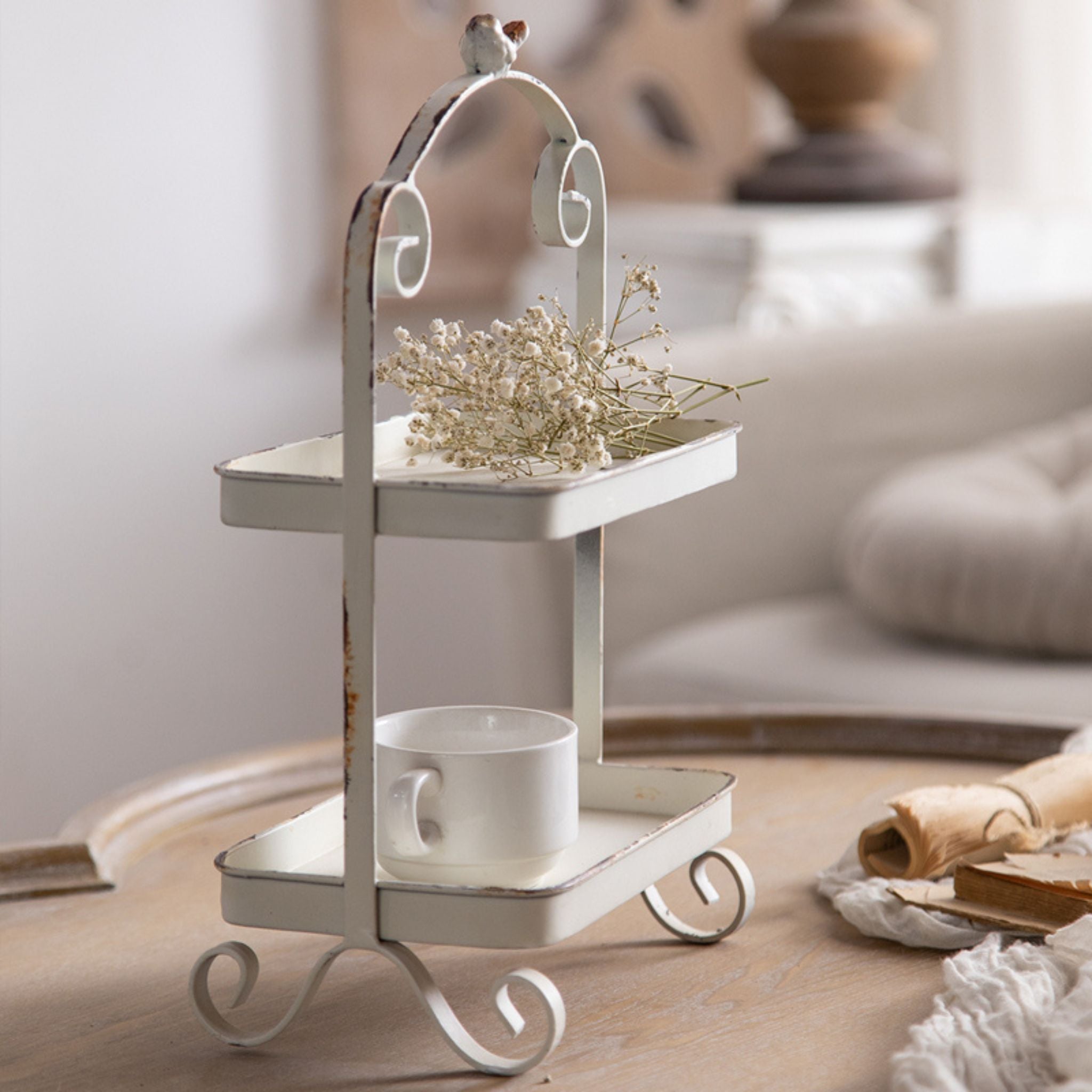 French Provincial two tier tray stand in distressed white styled on a table
