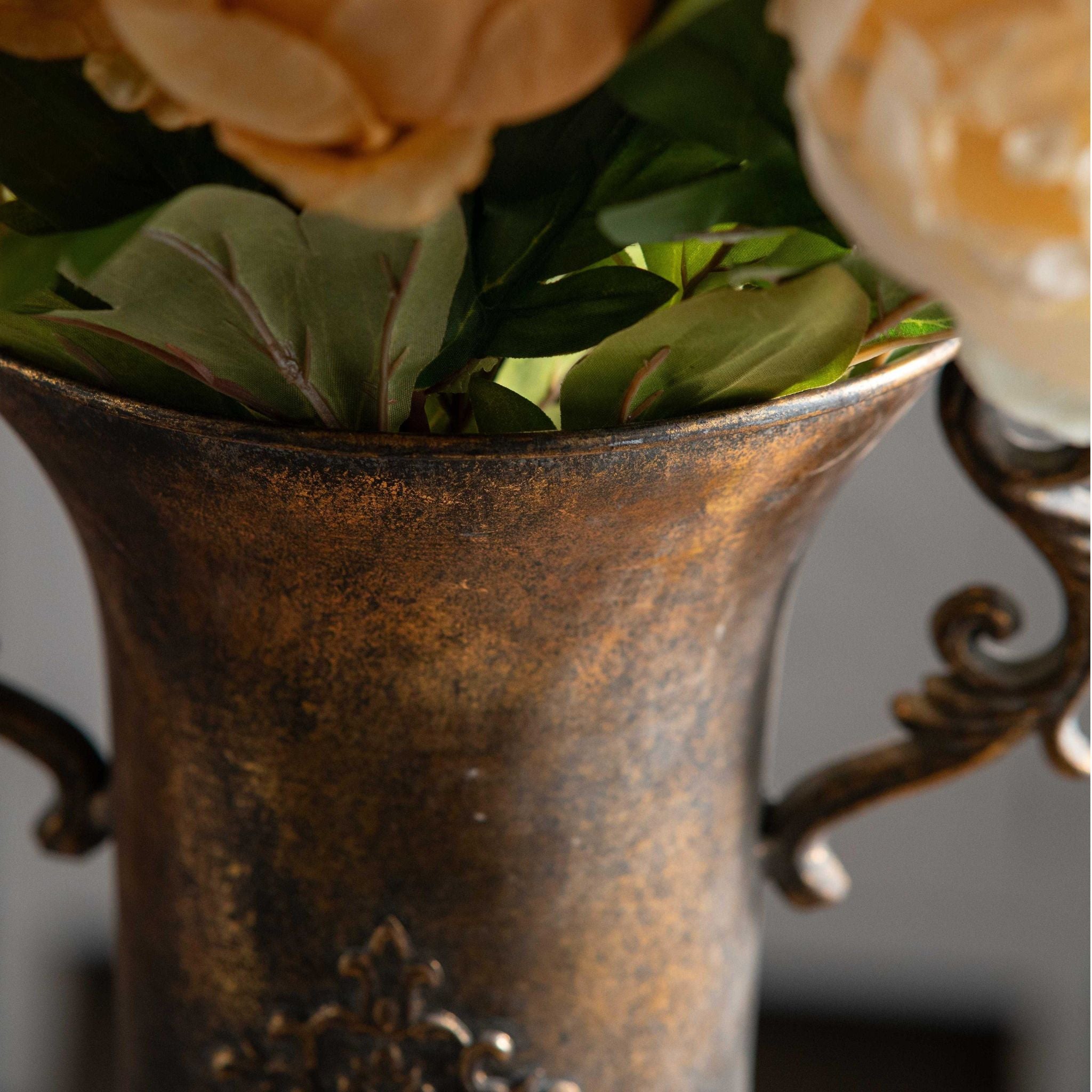 Close-up of the Coralie urn vase flared rim and handle with flowers