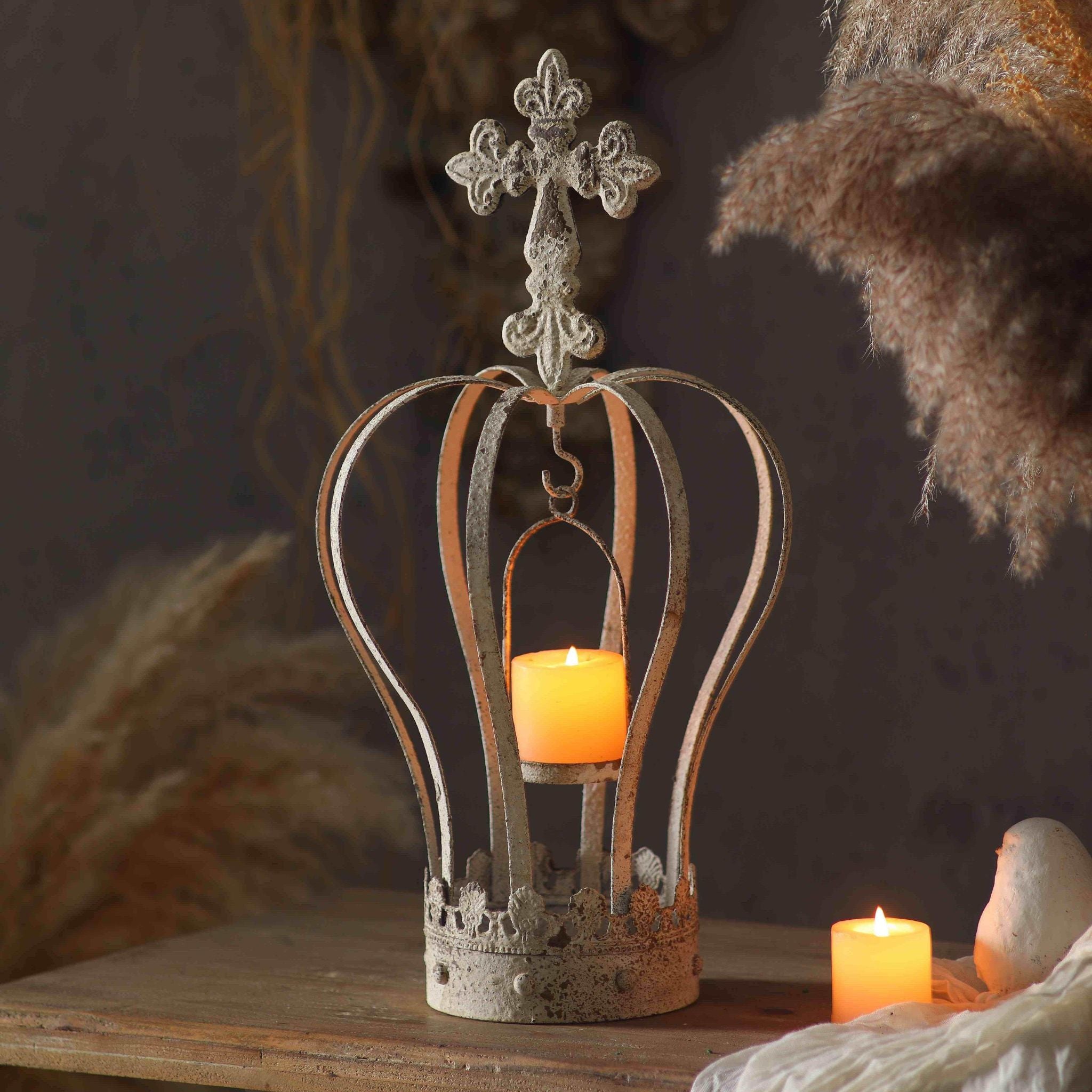 Blanche crown candle holder styled on a console with a lit candle inside, dried grasses behind 