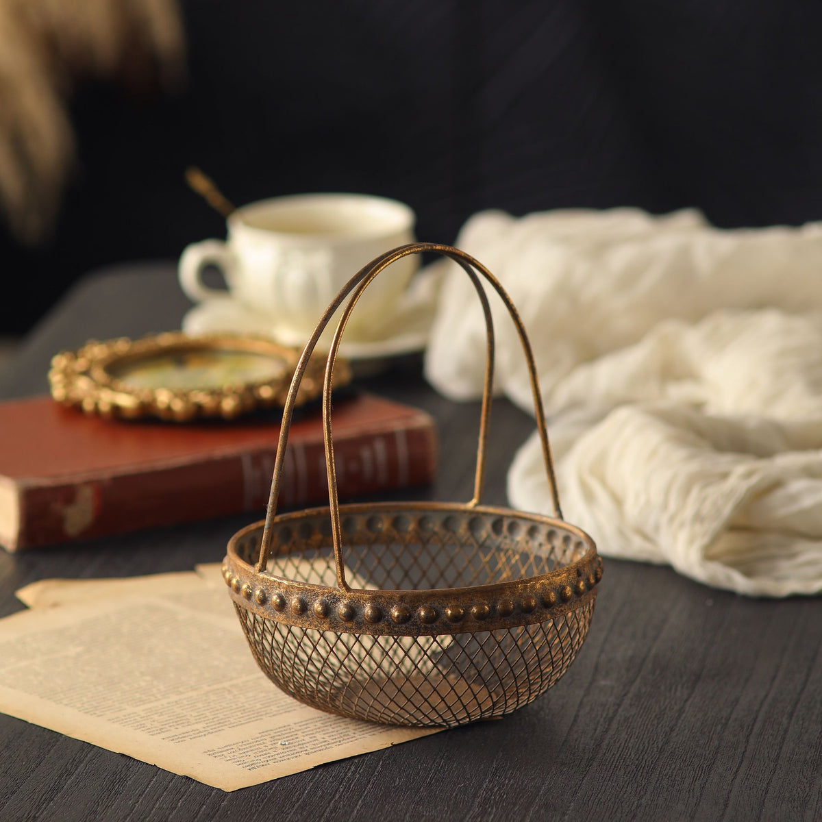 Diane single wire basket with tall arched handle and beaded rim in worn antique gold.