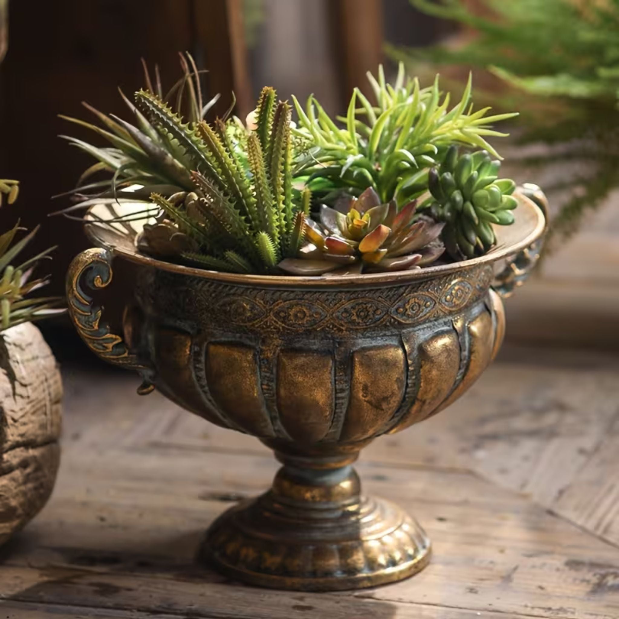 Dominique footed urn planter in antique brass, styled with a succulent arrangement.